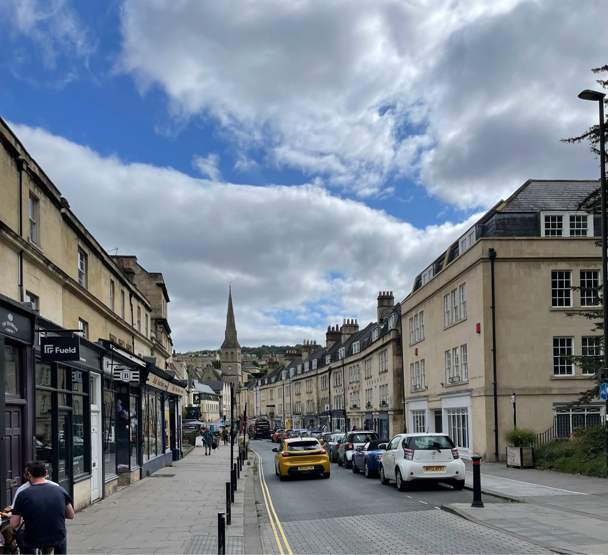 Pic of a Bath street - with the houses all made from the lovely yellow limestone Bath is famous for -  with Church spire at the end