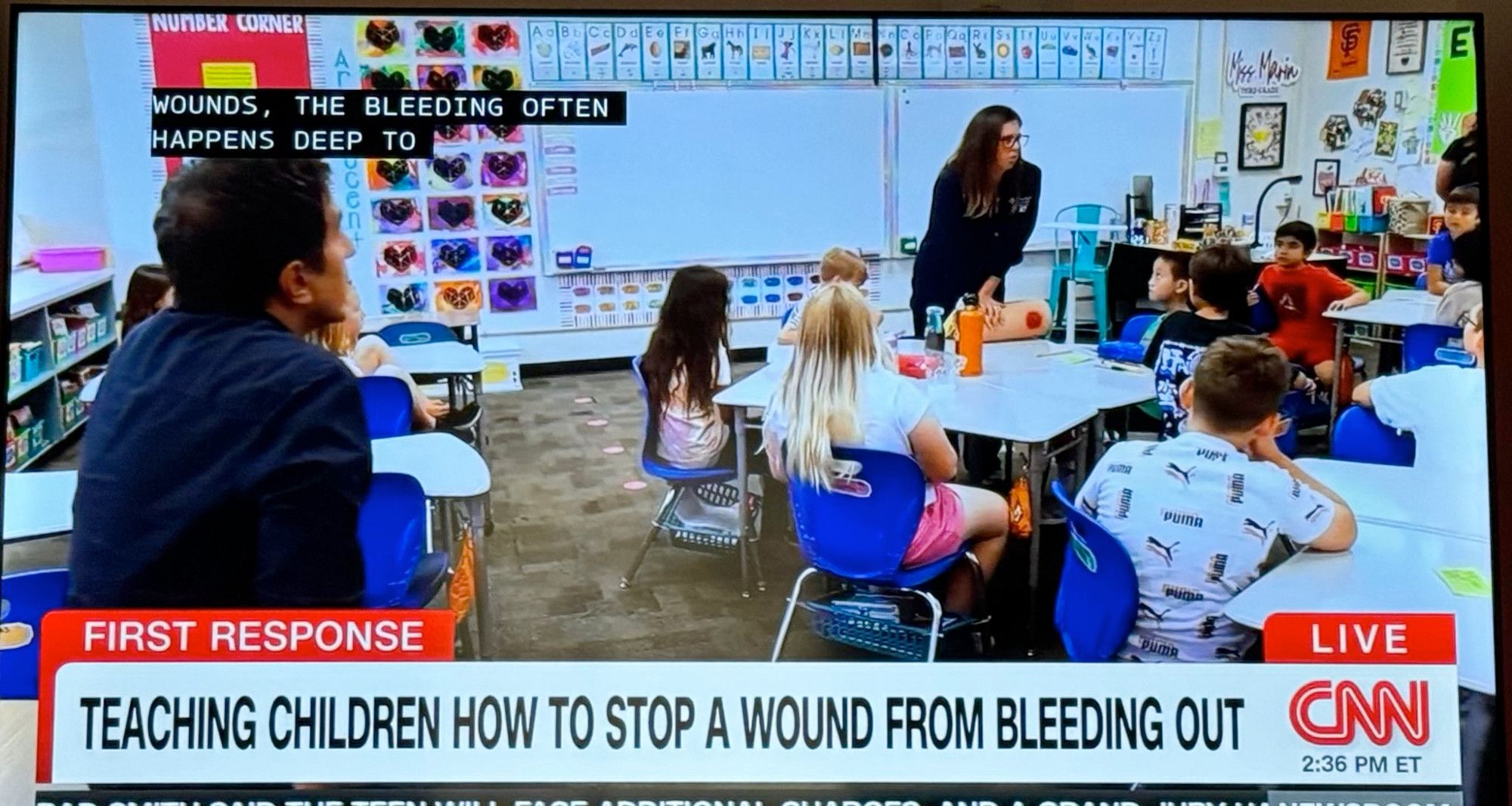 Elementary school students in a classroom learning to staunch bleeding in a gunshot wound.