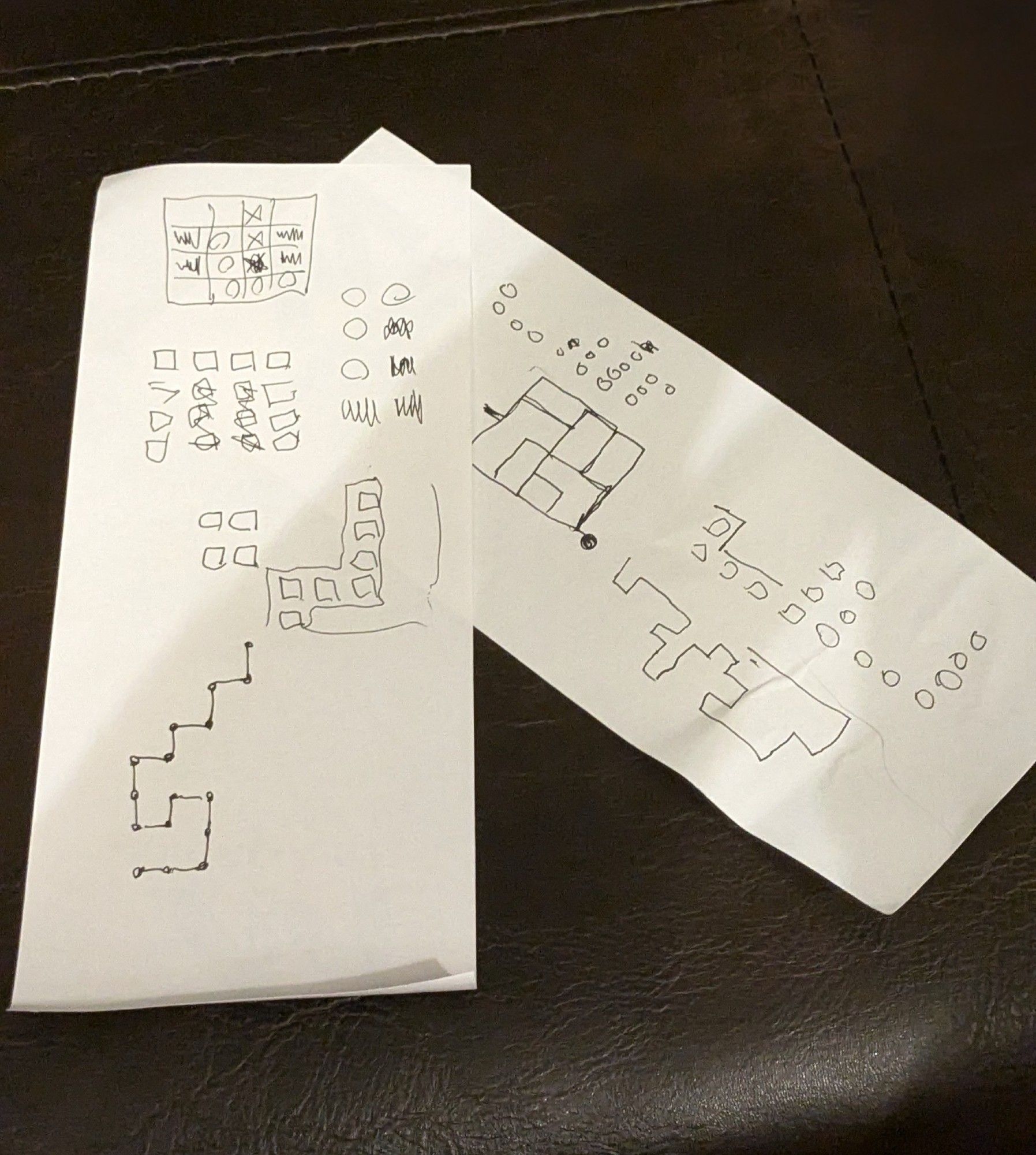 Pieces of paper with diagrams sketched to help solve puzzles in the game The Witness.