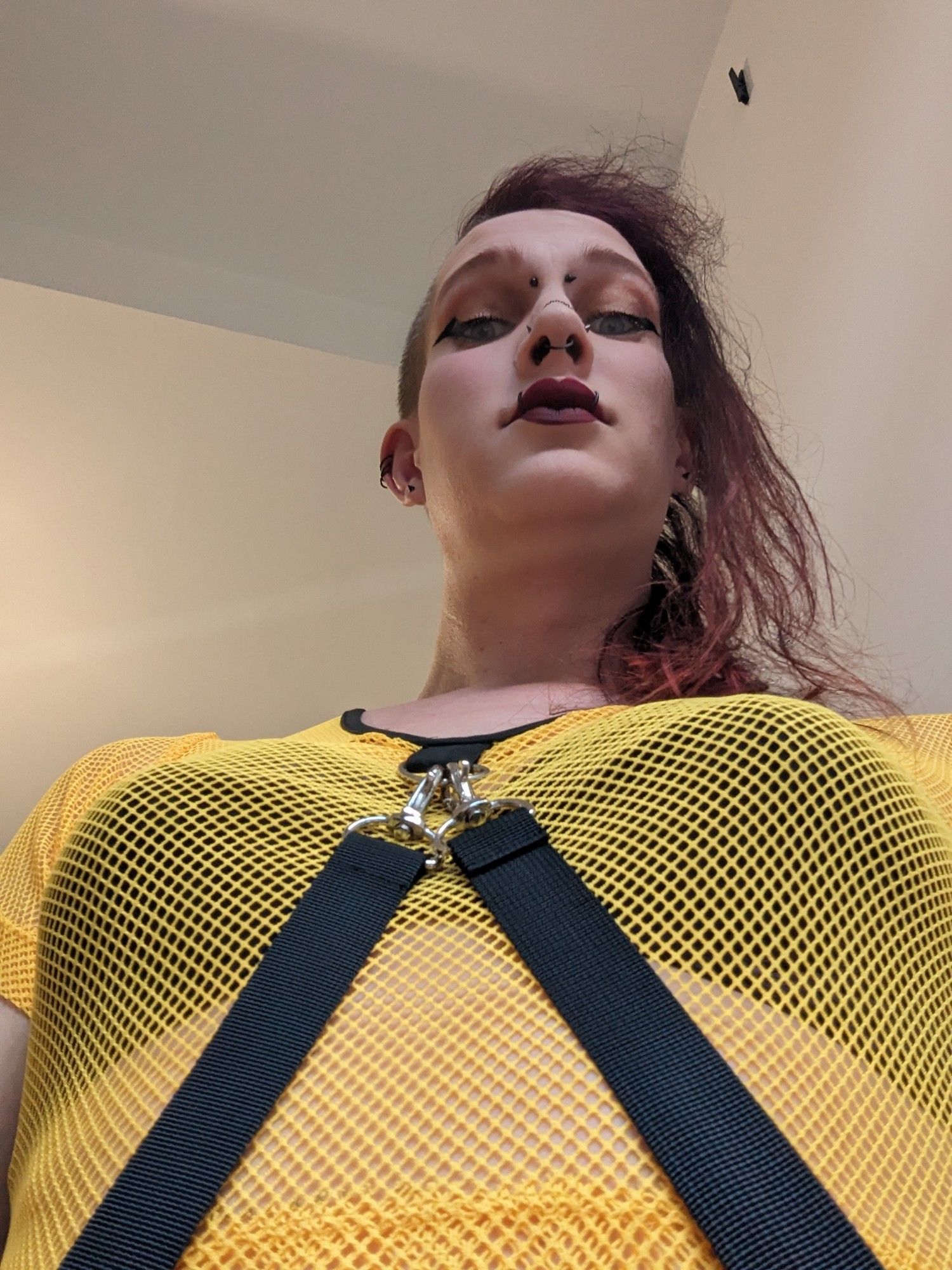 I'm wearing a bright yellow mesh top with two very grab-able straps hanging from the front. The picture is taken from about my waist height looking up