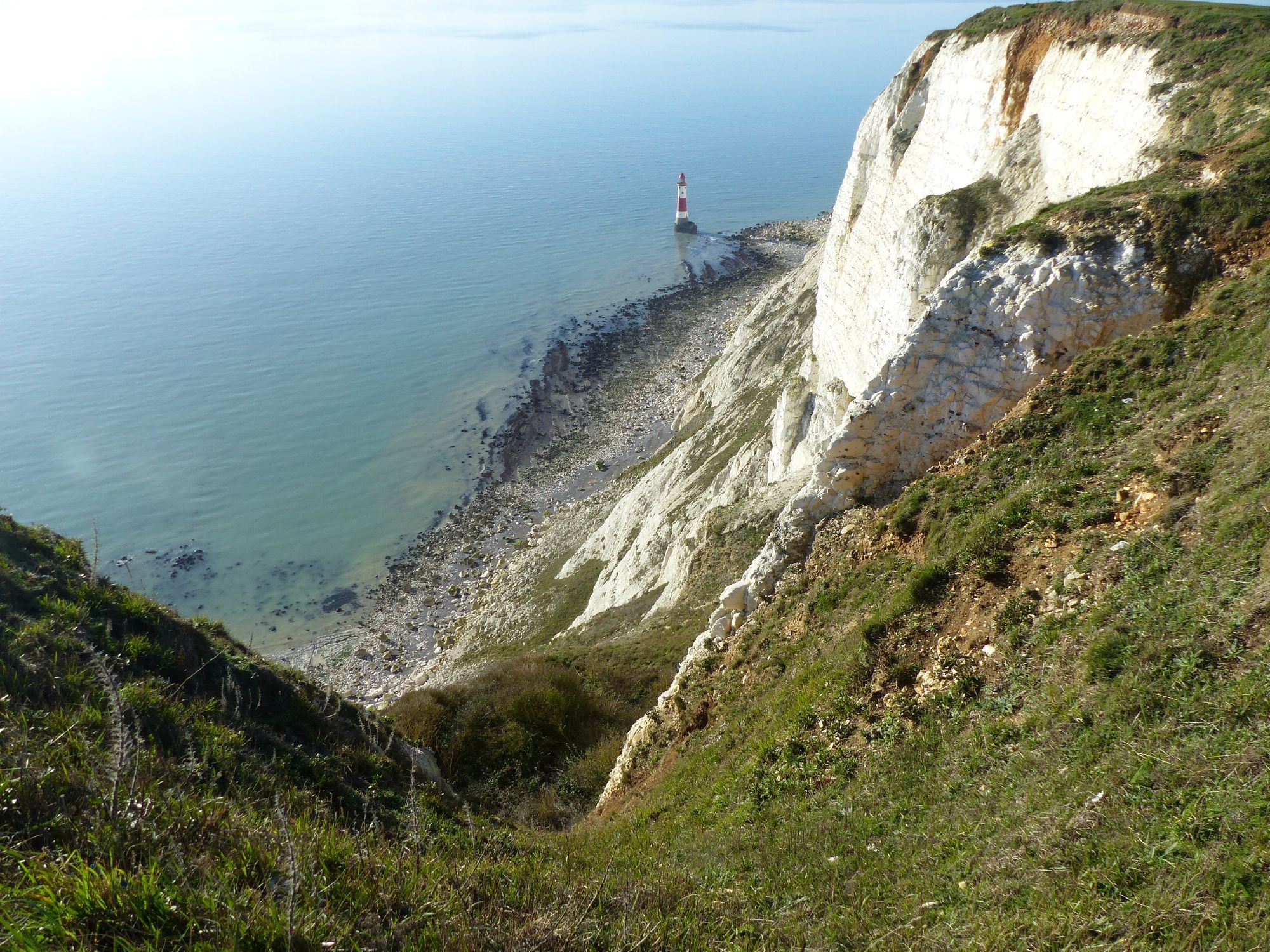 Beachy Head, East-Sussex. Grassy and white cliffs and sea including a red and white lighthouse

Rots naar zee. Het eerste stuk groen, daarna witte krijtrots met een stukje kiezelstrand en zee, inclusief een kleine rood witte vuurtoren.