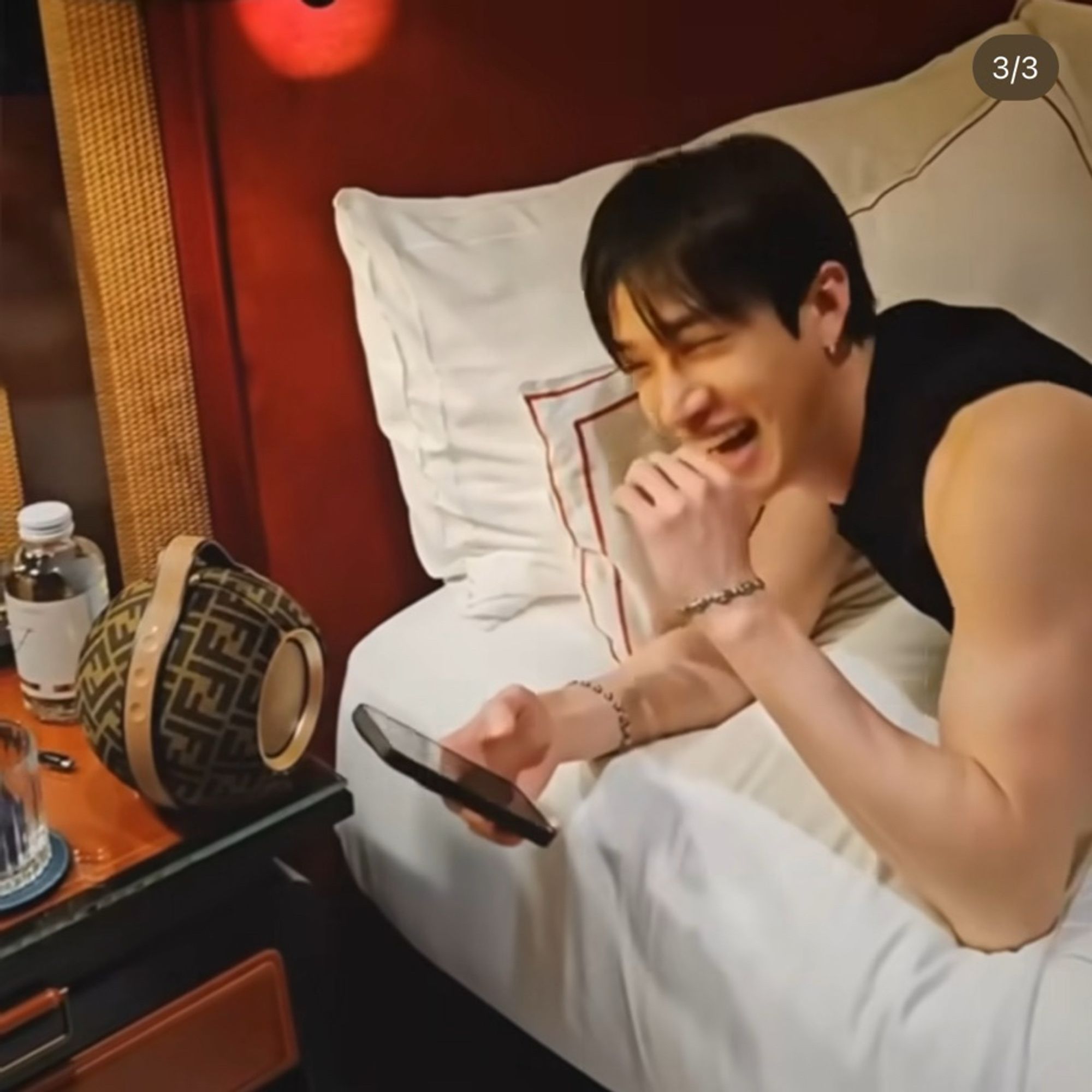 Screenshot of a video, Chan is in the bed using his phone and then starts laughing