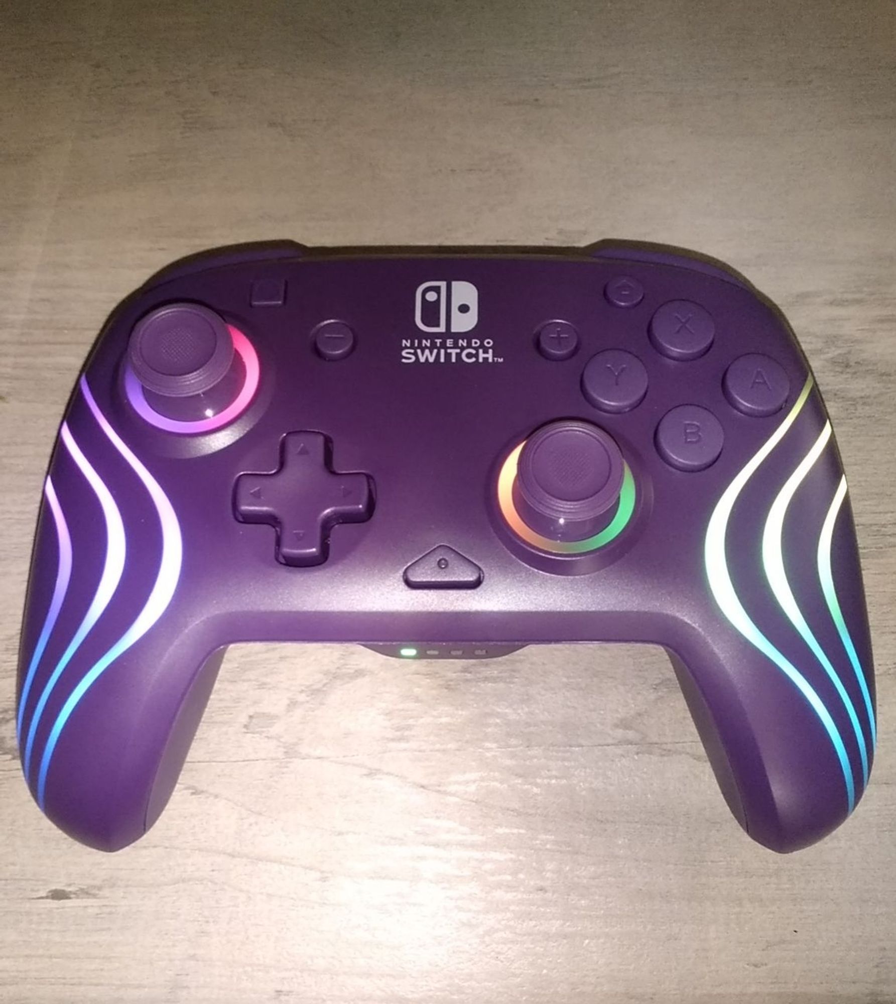 A PDP Afterglow Wave controller for Nintendo Switch. It's purple with LED lights.