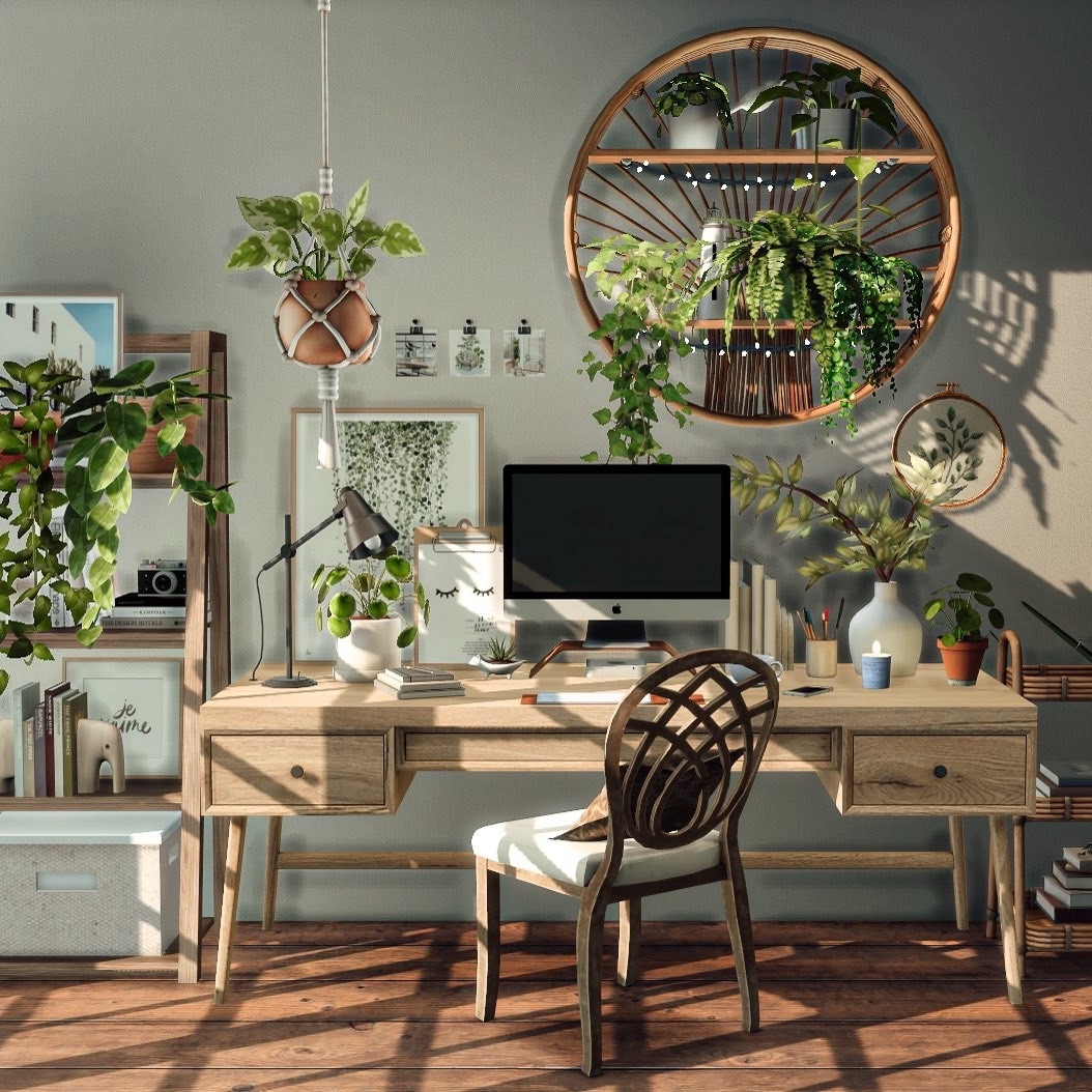 Aesthetic wooden desk setup built in The Sims 4 with a range of green plants, Mac , lamp, candles, books, shelving and beautiful dramatic light streaming in. 