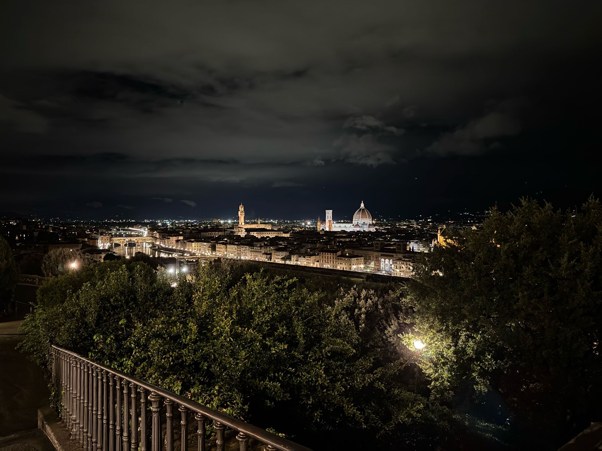 A photo of the skyline of Florence by night. The historic city is brightly lit by all the street lights and the monumental buildings are brightly visible