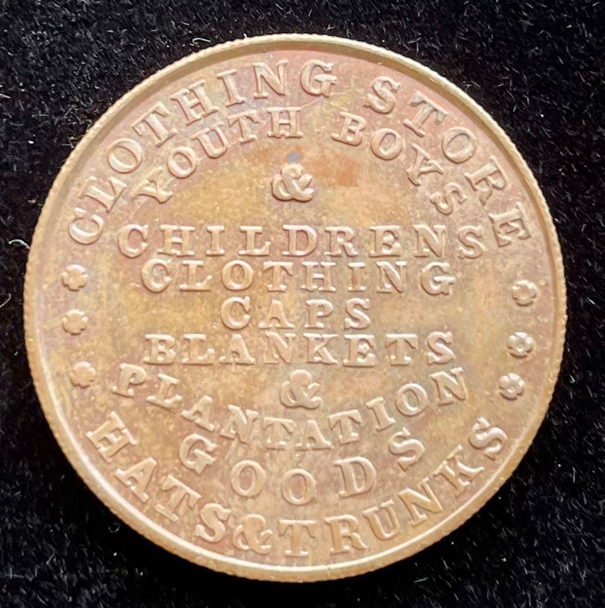 1850s metallic token from New Orleans clothing supplier N.C. Folger. The text reads "Caps Blankets & Plantation Goods"