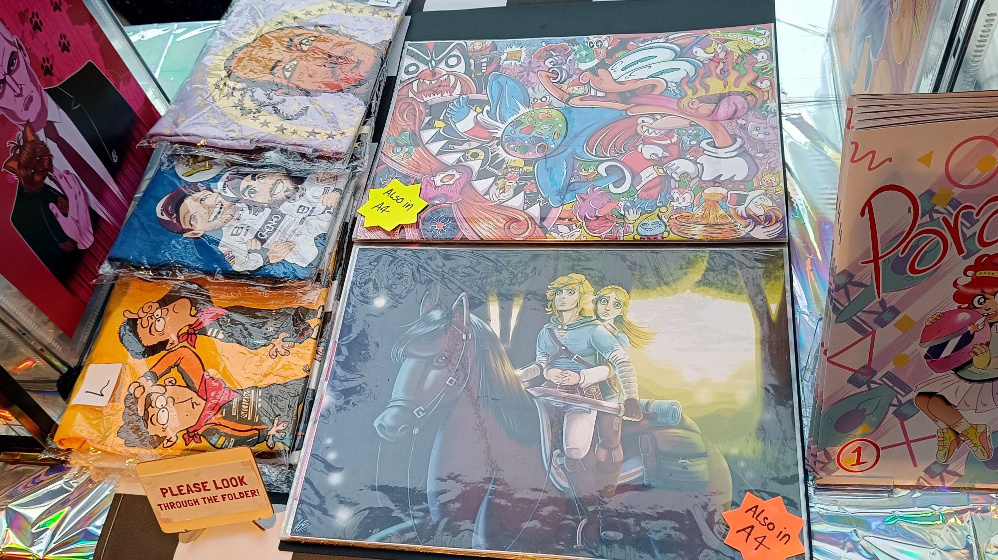 Photo of the middle of my table at the DCC trade hall, featuring prints and t-shirts.