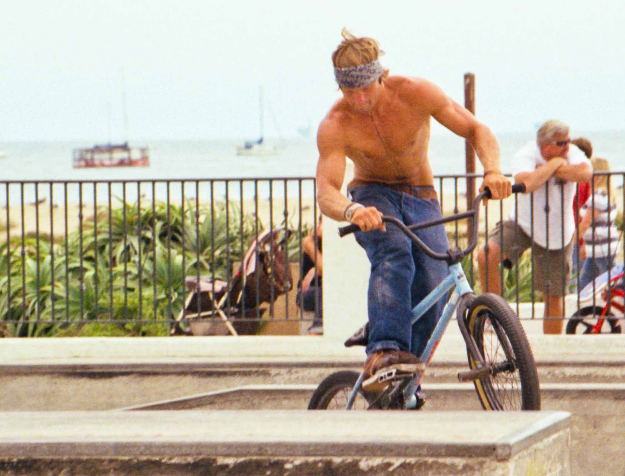 Skaters and bikers enjoying a skate-park at the beach on cloudy summer day. Shot on film. ~ Ventura, California