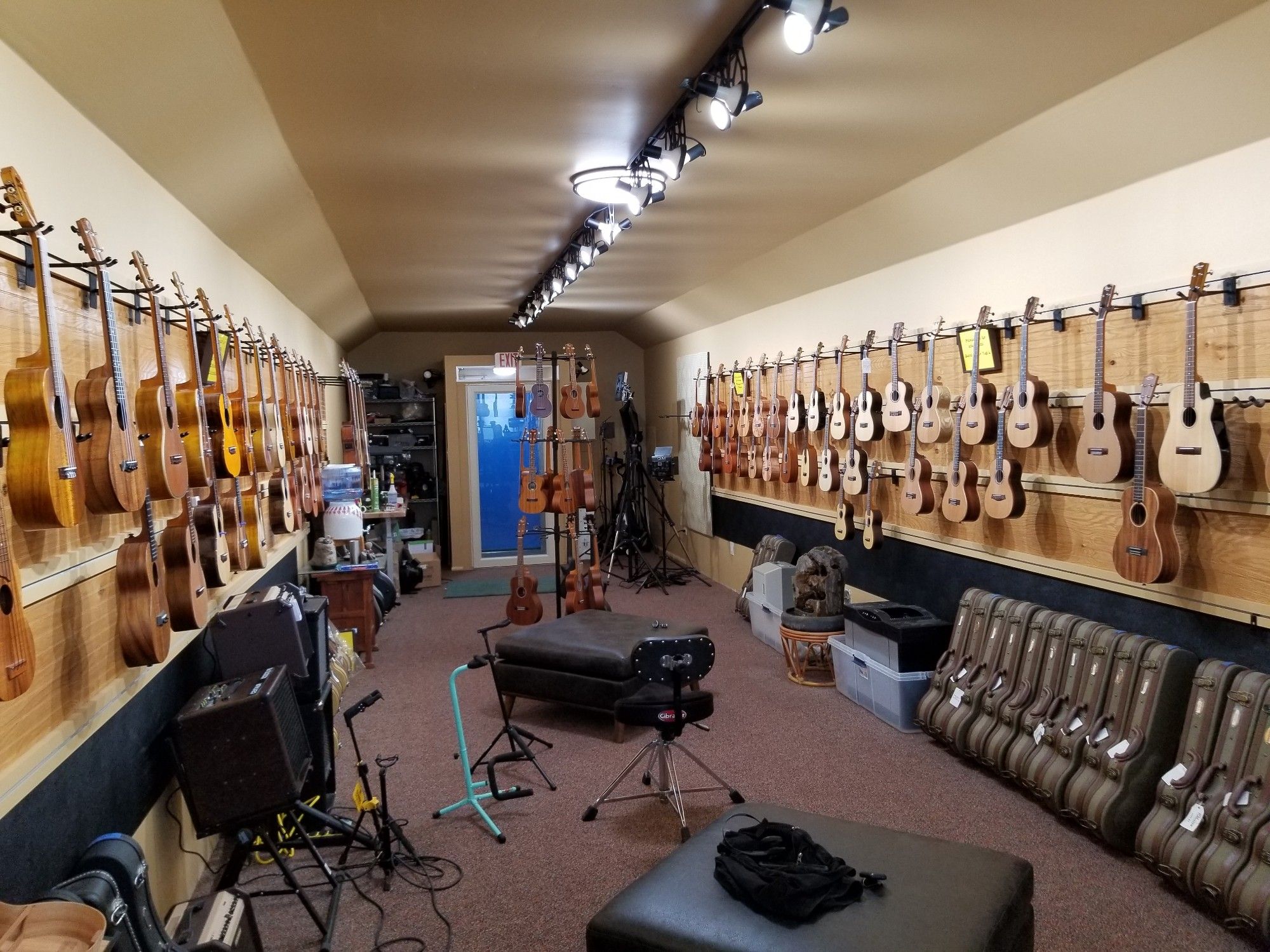 A room with two long walls packed with ukuleles