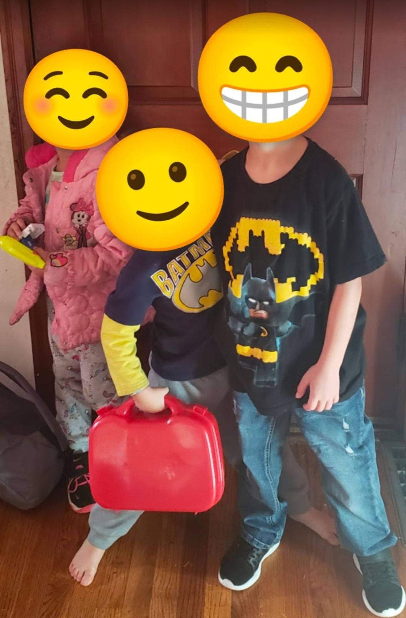 Photo of 3 kids who were abandoned with zero notice. 2 boys and a girl standing in front of a door on the first day of school that year. Their faces are covered with smile emoji for safety/privacy.