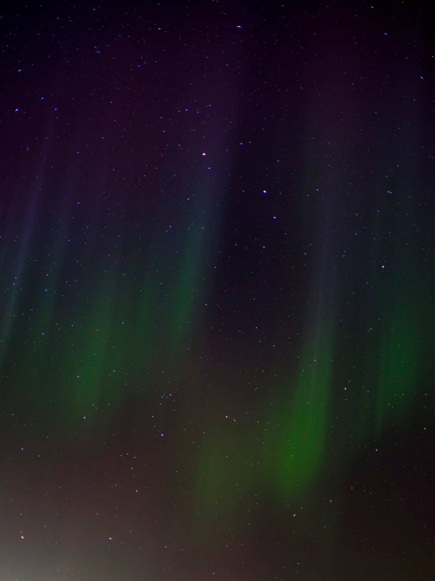 Green and purple aurora in a star filled sky