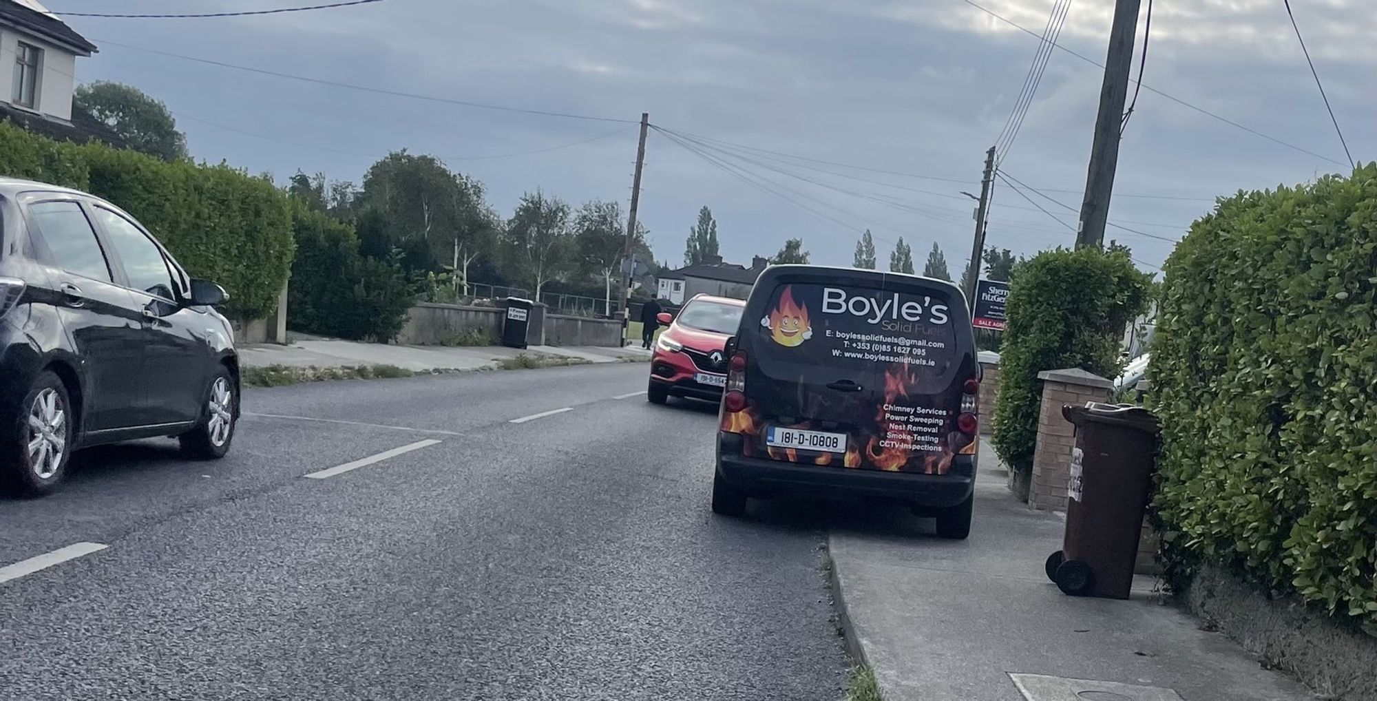 Rosemount estate, Dublin 14 - small van branded 'Boyles Solid Fuels' parked with half the van width blocking about two thirds of the footpath width, and a wheely bin blocking the rest of the footpath.