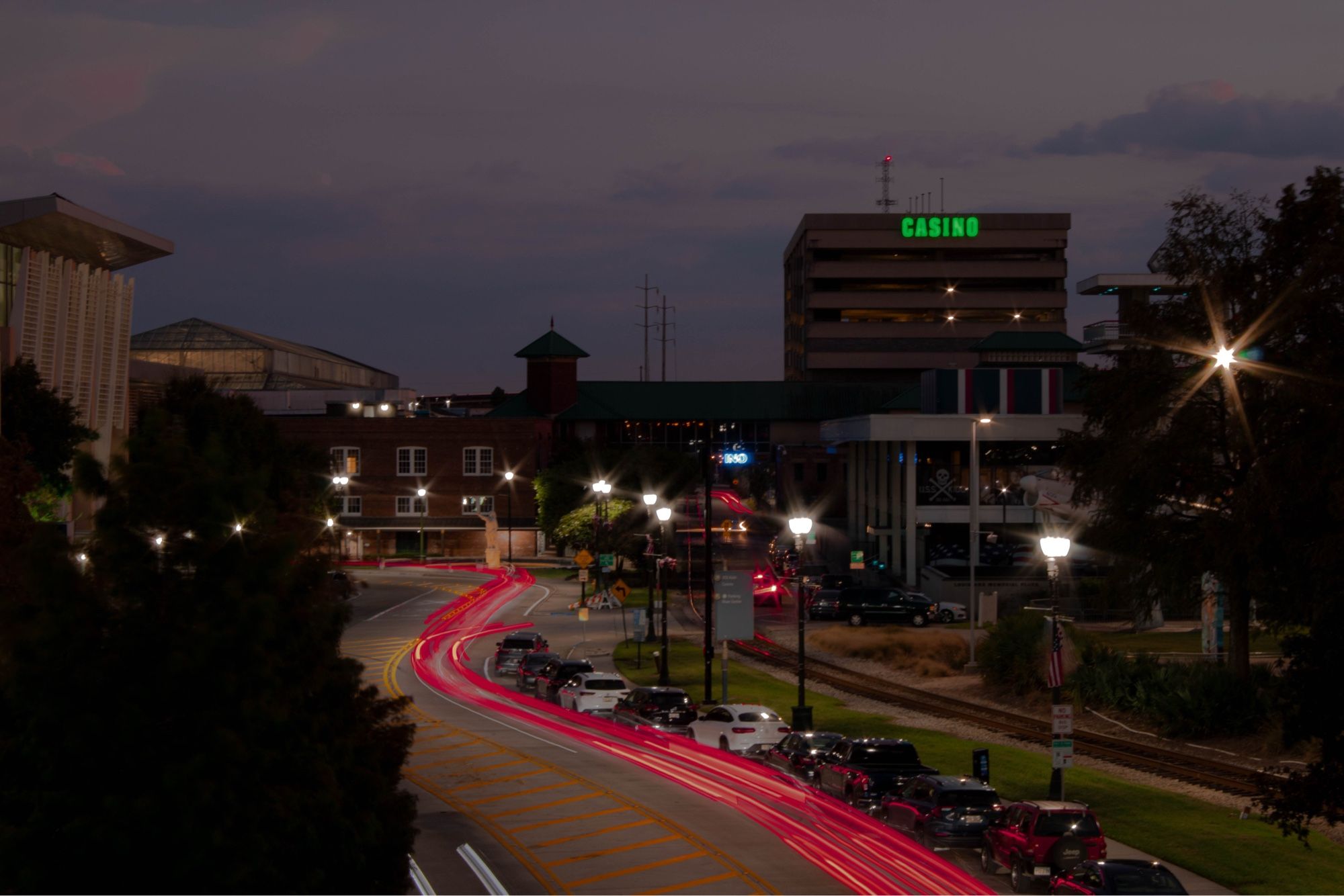 long exposure image of a road in baton rouge streaked with brake lights, with buildings in the background