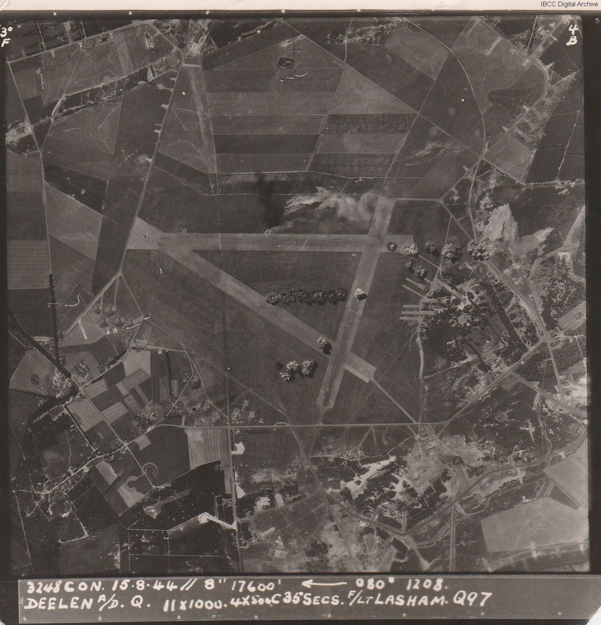 Target photograph showing an airfield with triangle of runways with buildings bottom and right. Bomb bursts are visible across the airfield. Caption '3248 CON. 15.8.44// 8" 17600, 080, 1208, DEELEN A/D Q., 11x1000, 4x500C35secs. F/Lt LASHAM, Q97'.
IBCC Digital Archive item 32521