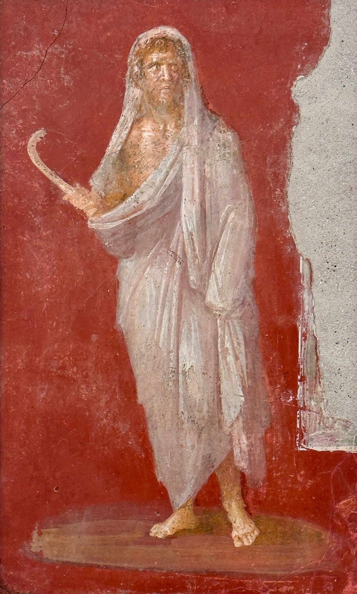 The god Saturn holds his sickle and has pulled his white toga over his head, as always, in a veil (the MANN calls this a ‘winter cloak’ - but it seems to be a toga). Because Saturn was always shown veiled, his were the only worshippers that did *not* wear veils when sacrificing in his honor.

62-79 CE

House of the Dioscuri (VI 9, 6-7, atrium 37), Pompeii.

Museo Archeologico Nazionale di Napoli (MANN inv. 8837).