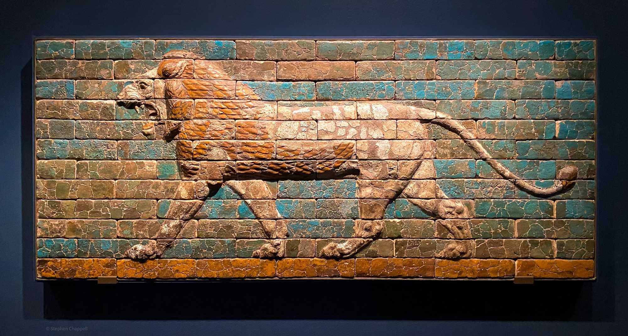The Assyrian Empire fell before the combined onslaughts of Babylonians and Medes in 614 and 612 BCE. In the empire's final days, Nabopolassar (r. 625–605 BCE), who had been in Assyrian service, established a new dynasty with its capital in Babylon. During the reign of his son, Nebuchadnezzar II (r. 604–562 BCE), the Neo-Babylonian empire reached its peak. This was largely attributable to Nebuchadnezzar's ability as a statesman and general. He maintained friendly relations with the Medes in the east while vying successfully with Egypt for the control of trade on the eastern Mediterranean coast. He is well known as the biblical conqueror who deported the Jews to Babylon after the capture of Jerusalem.

During this period Babylon became the city of splendor described by Herodotus and the Old Testament Book of Daniel. Because stone is rare in southern Mesopotamia, molded glazed bricks were used for building and Babylon became a city of brilliant color. Relief figures in white, black, blue, red, and yellow decorated the city's gates and buildings.

The main street of Babylon ran past the city's ziggurat, the royal palaces, perhaps the still-unlocated Hanging Gardens, and out through the Ishtar Gate to the Akitu House, where the city god Marduk ritually defeated the forces of chaos in the Babylonian New Year festival. The walls of this Processional Way were lined with colorful low-relief images of striding lions (sacred to Ishtar), and the gate itself with bulls (sacred to Adad) and Mushhushu snake-dragons (sacred to Marduk). Made of glazed bricks, they formed one of the most spectacular aspects of the city rebuilt by King Nebuchadnezzar Il in the 6th century BCE.

This style of decoration was copied by the Achaemenid Persians a century later for their palaces and city gates.

From the Processional Way, Babylon (Iraq)
Glazed polychrome bricks
Neo-Babylonian period, reign of Nebuchadnezzar II, 605-562 BCE

Met Museum, New York (31.13.1), at the Getty Villa Museum