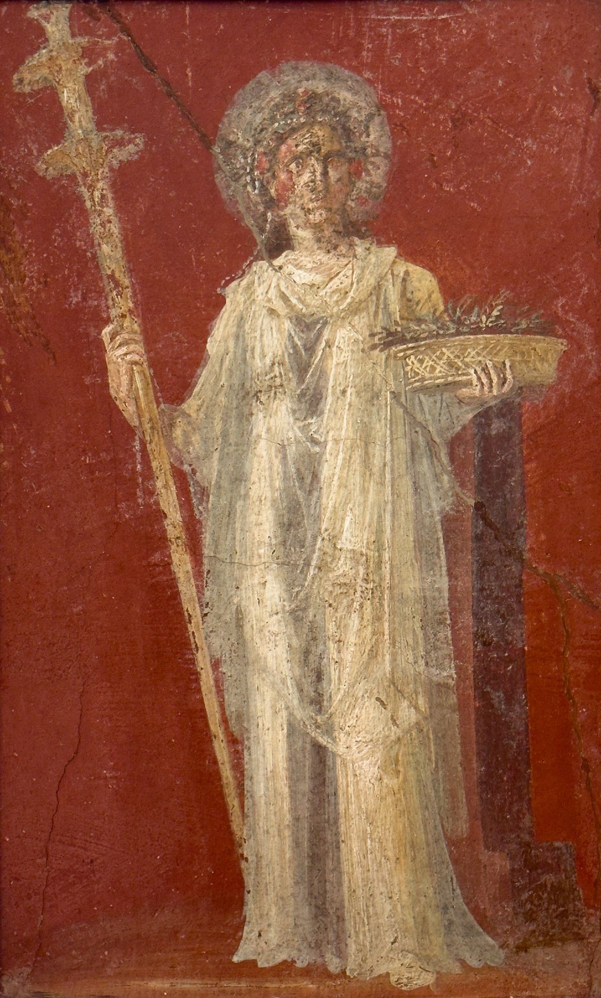 The goddess Ceres holds a wicker basket filled with wheat spears in her left hand, and a large golden torch (far taller than her) in her right. There are strings of beads and flowers in her hair, as she’s a goddess of fertility and plenty. She also has a nimbus around her head. Her clothing is complex, consisting of a long white chiton/tunic, with transparent veils on top (there also seems to be gold patterns on the ends of the veil, but they’re very faded), and a purple cloth hanging from the hand that holds the basket. She’s on a red background. 

62-79 CE, House of the Dioscuri, Pompeii

Museo Archeologico Nazionale di Napoli (MANN inv. 9454)