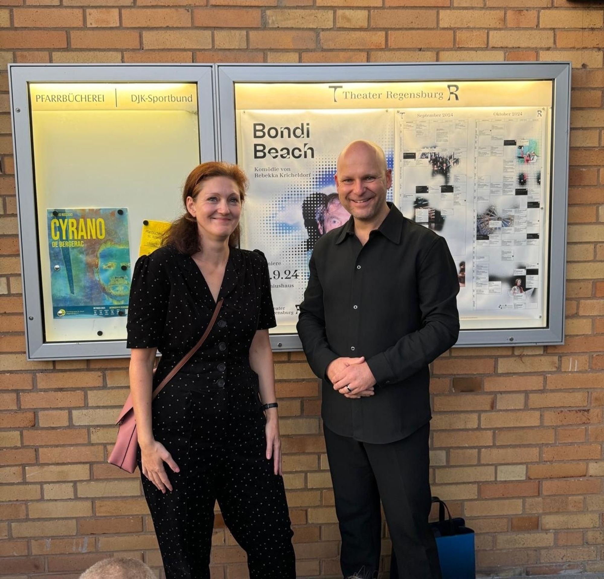 Autorin Rebekka Kricheldorf (links) vor der heutigen Premiere ihres Stückes BONDI BEACH mit Intendant Sebastian Ritschel (rechts) am Antoniushaus vor dem Stückplakat.
📷 Stina Walterbach.