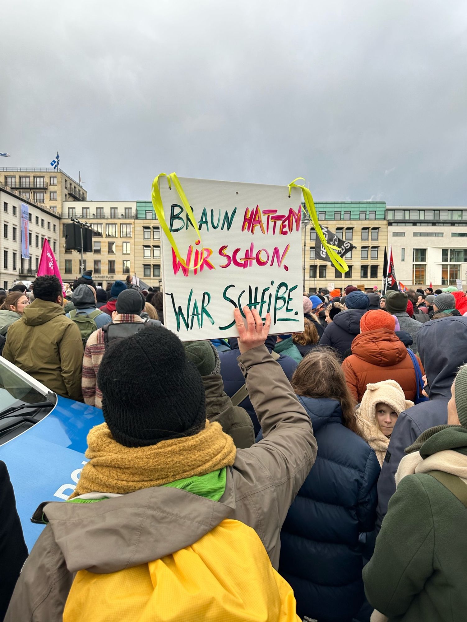 Frau auf einer Demonstration zeigt ein Schild auf dem steht: „Braun hatten wir schon . War scheiße.“