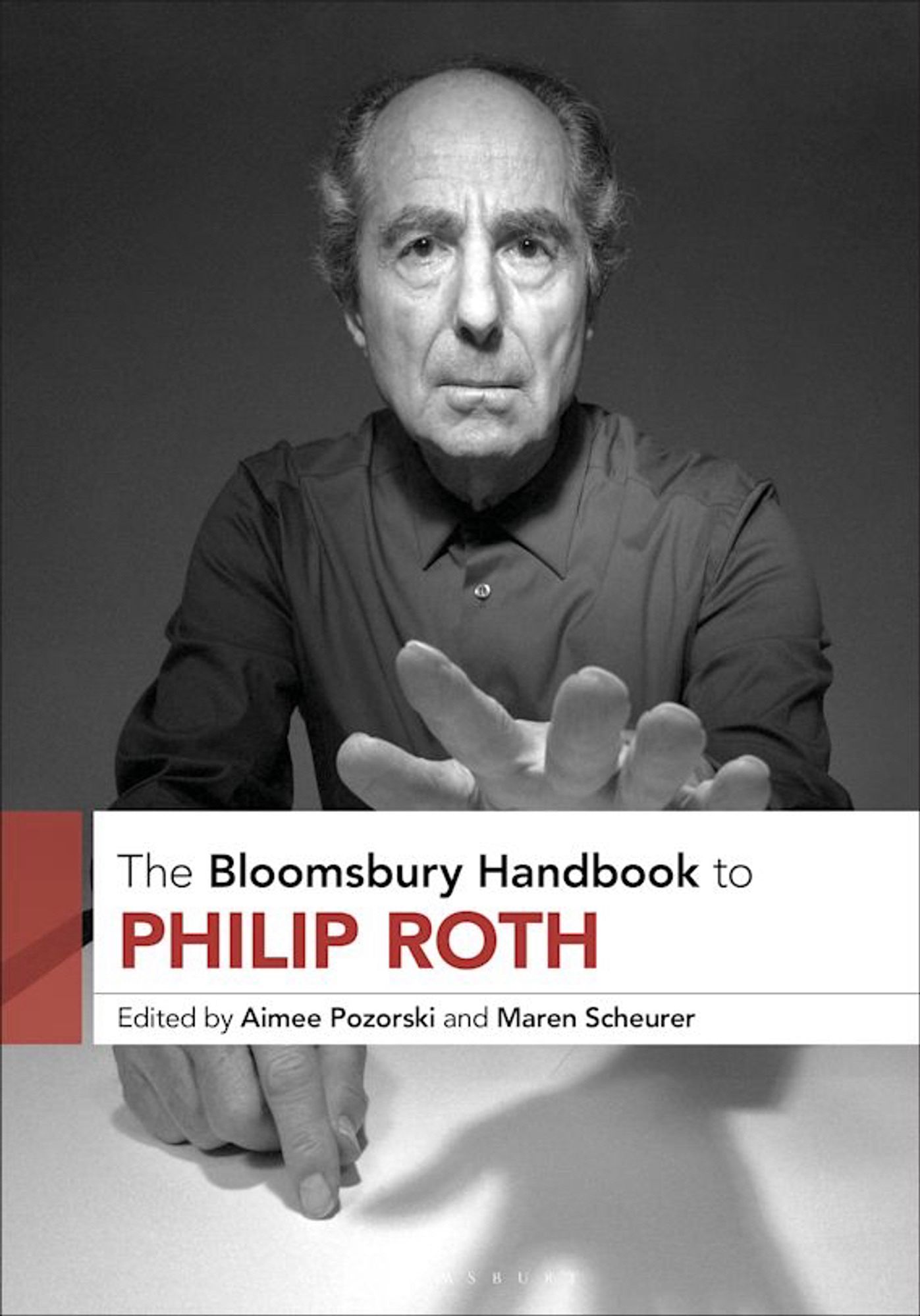 Aimee Pozorski and Maren Scheurer (Editors): The Bloomsbury Handbook to Philip Roth book cover with a photograph of Roth reading towards the viewer with one hand.