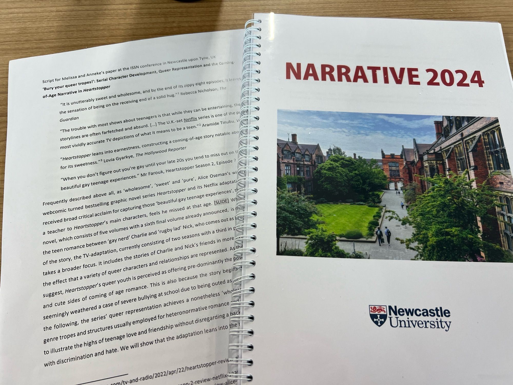 Photo of a printed copy of a paper titled ‘Bury your queer tropes!’: Serial Character Development, Queer Representation and the Coming-of-Age Narrative in ‘Heartstopper’ by Anneke Schewe and Melissa Schuh from Kiel university, shown next to the ring bound conference programme booklet for the Narrative 2024 conference at Newcastle university.