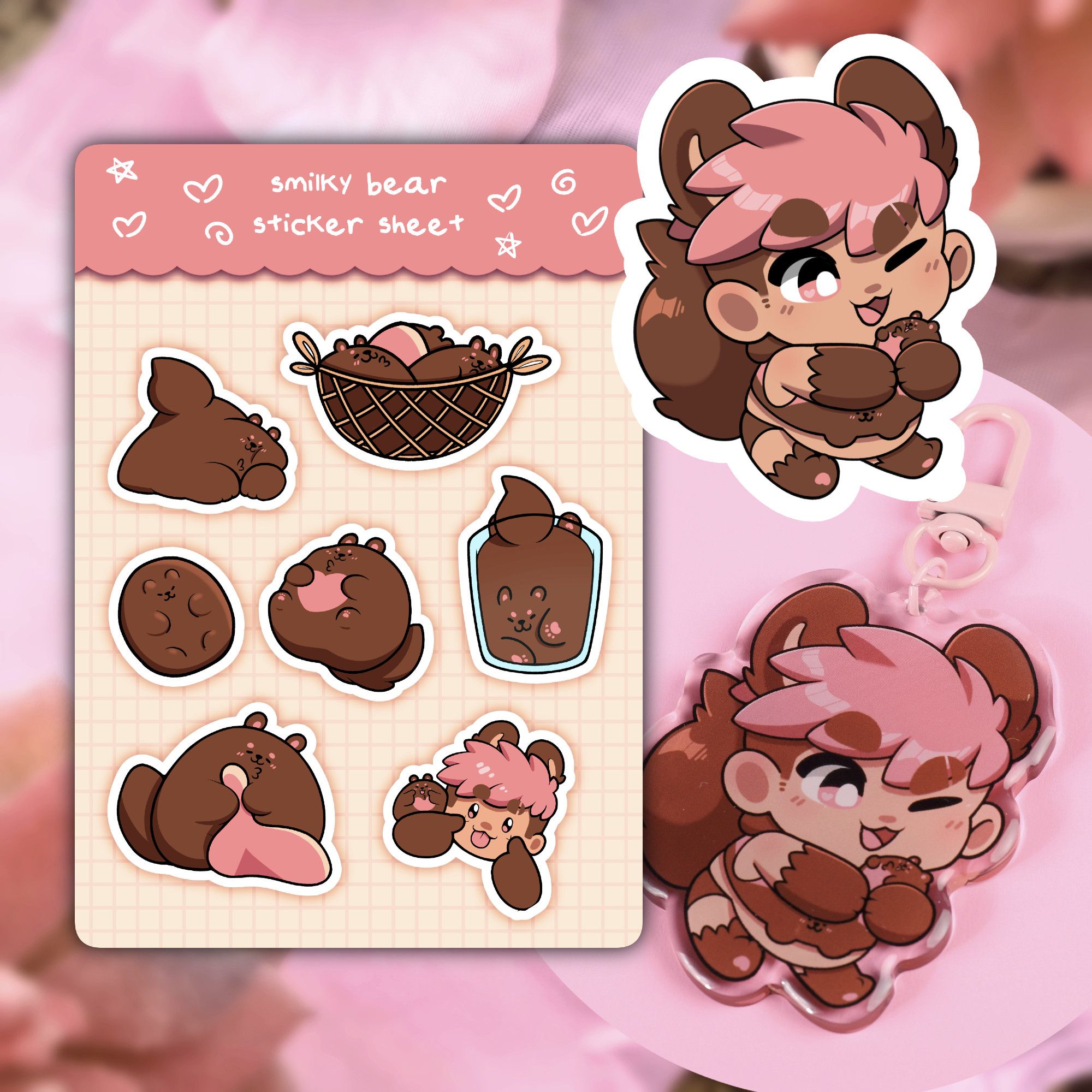 A sticker sheet, a sticker, and an acrylic charm featuring Smilky in their Bear form