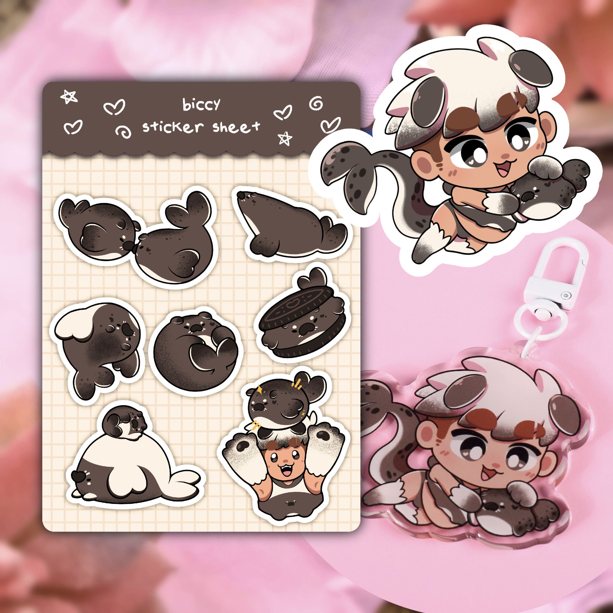 A sticker sheet, a sticker, and an acrylic charm featuring Smilky in their Seal form