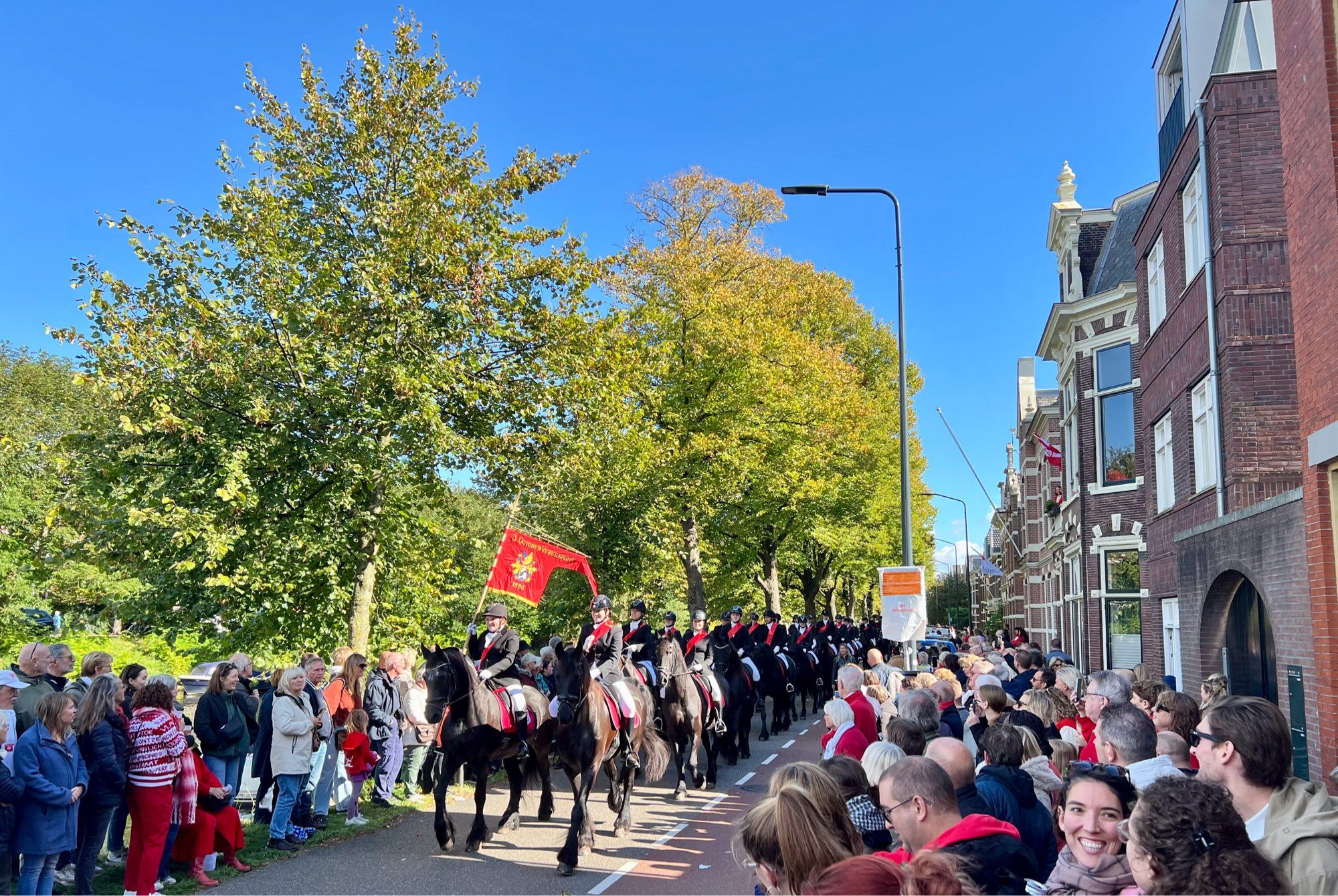 Begin van de stoet met veel paarden op de Zoeterwoudsesingel in Leiden, ter gelegenheid van 450 jaar 3 oktober. Veel toeschouwers langs de weg