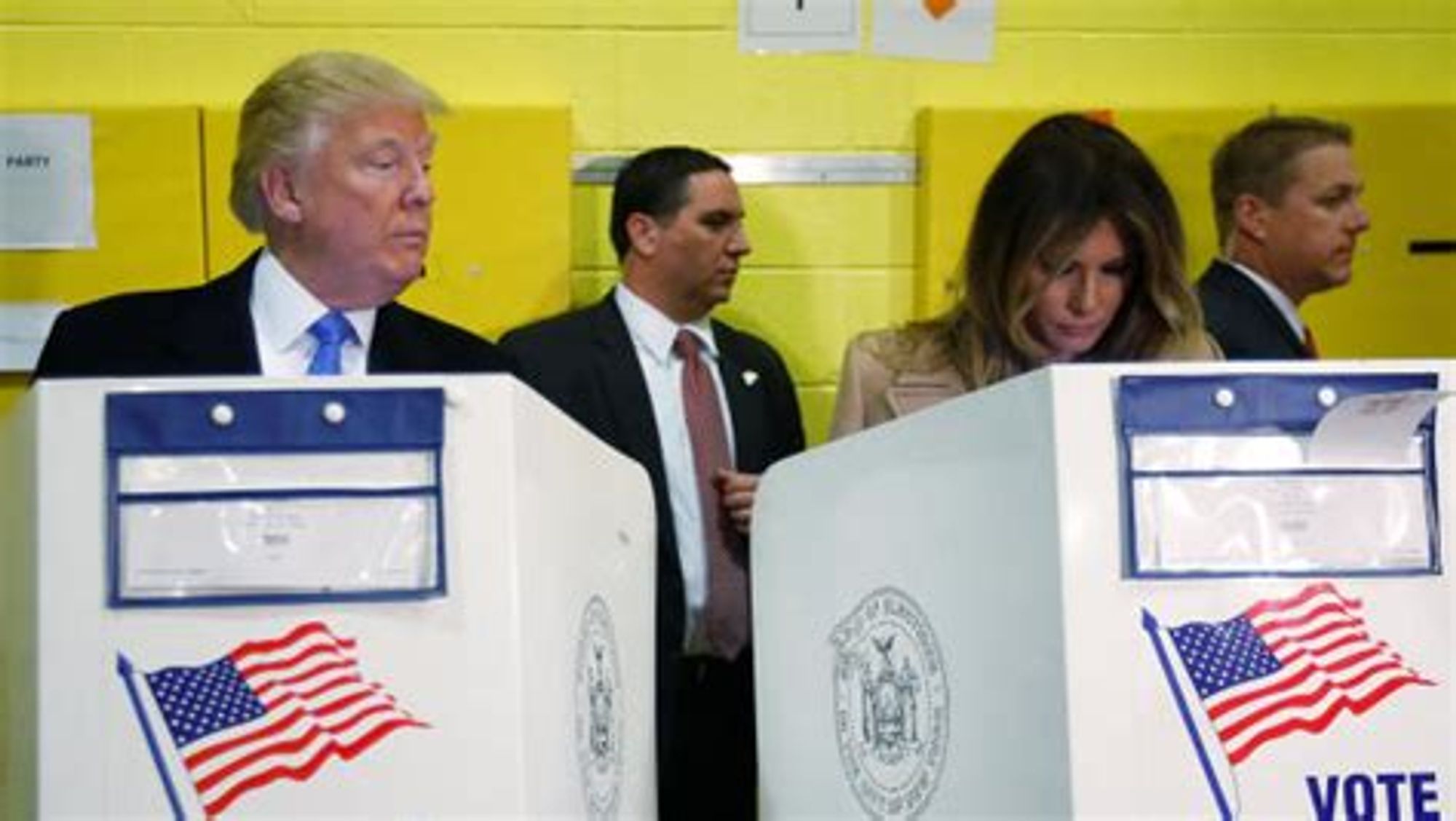 Donald Trump looks at Melania's ballot as they are voting