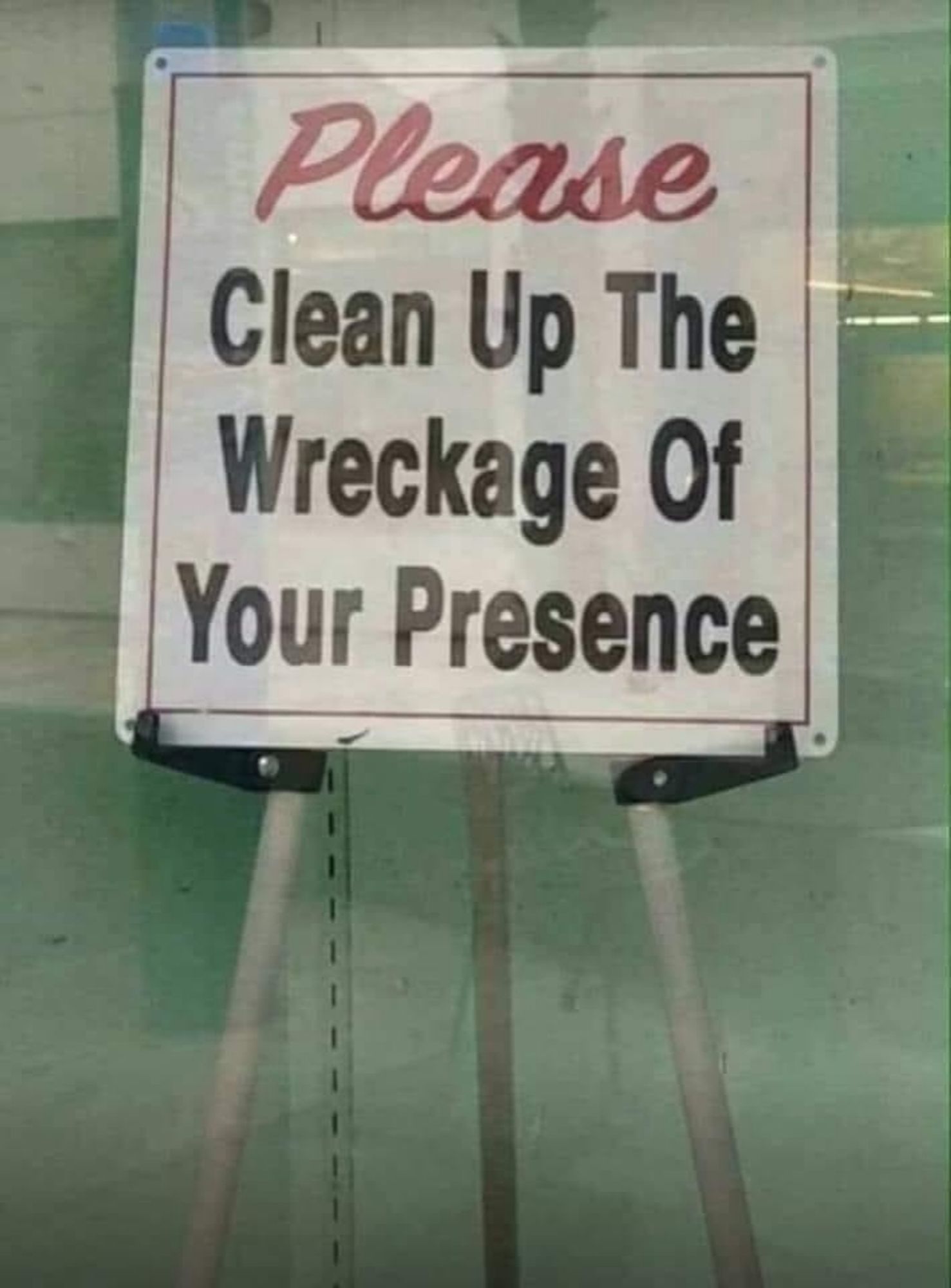 A sign reading: "Please clean up the wreckage of your presence"