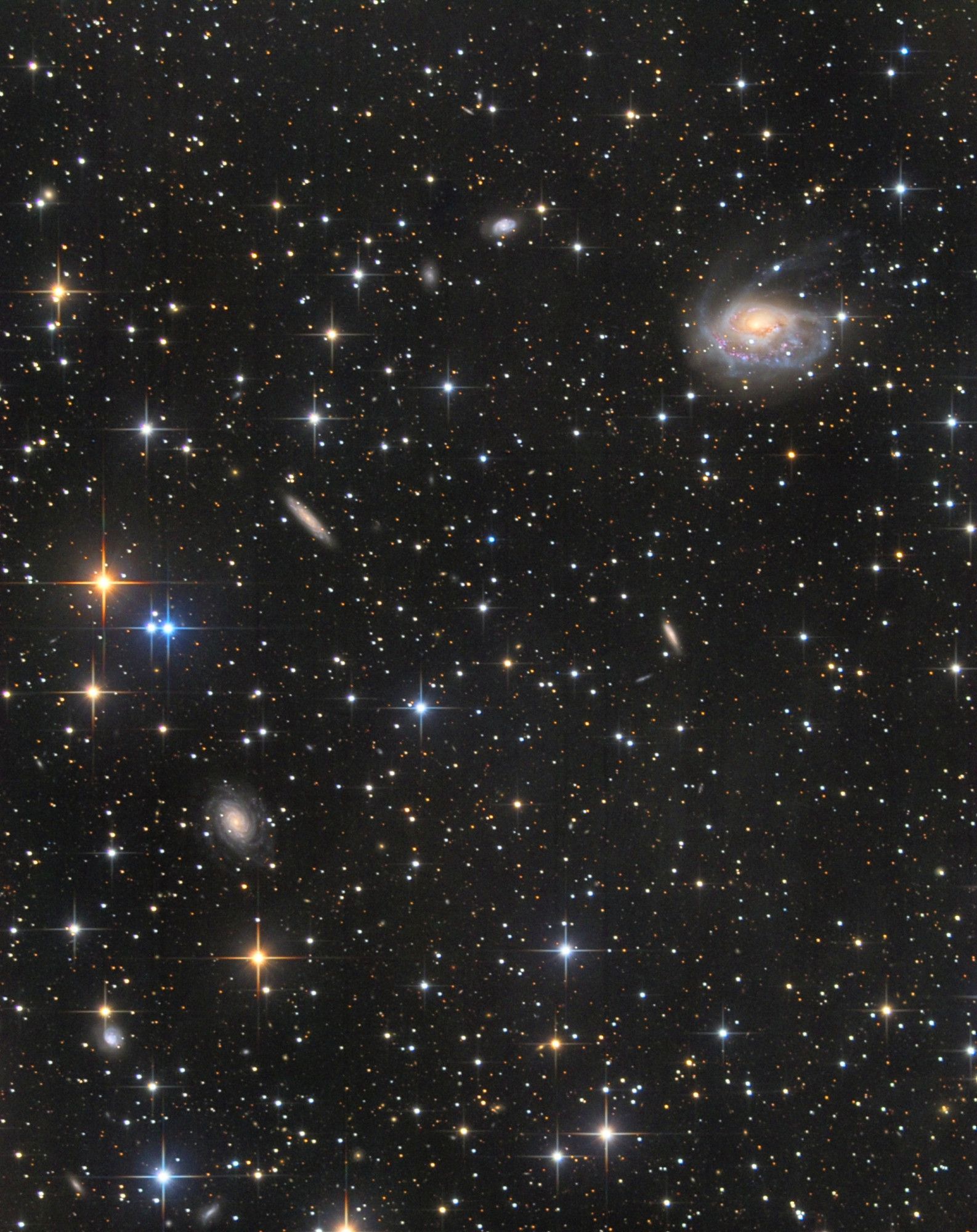 "NGC 1961, seen in the top-right of this star-studded field, is a spiral galaxy with notably distorted features. Despite these irregular, outer spiral arms, no companion galaxy or evidence of a recent merger (such as double nuclei) has been detected. The distortion suggests dynamic forces at play, yet the source of this disruption remains a mystery. The galaxy resides in the constellation Camelopardalis, with stars spread across the scene, adding to the cosmic wonder of this enigmatic system." #space #astrophotography