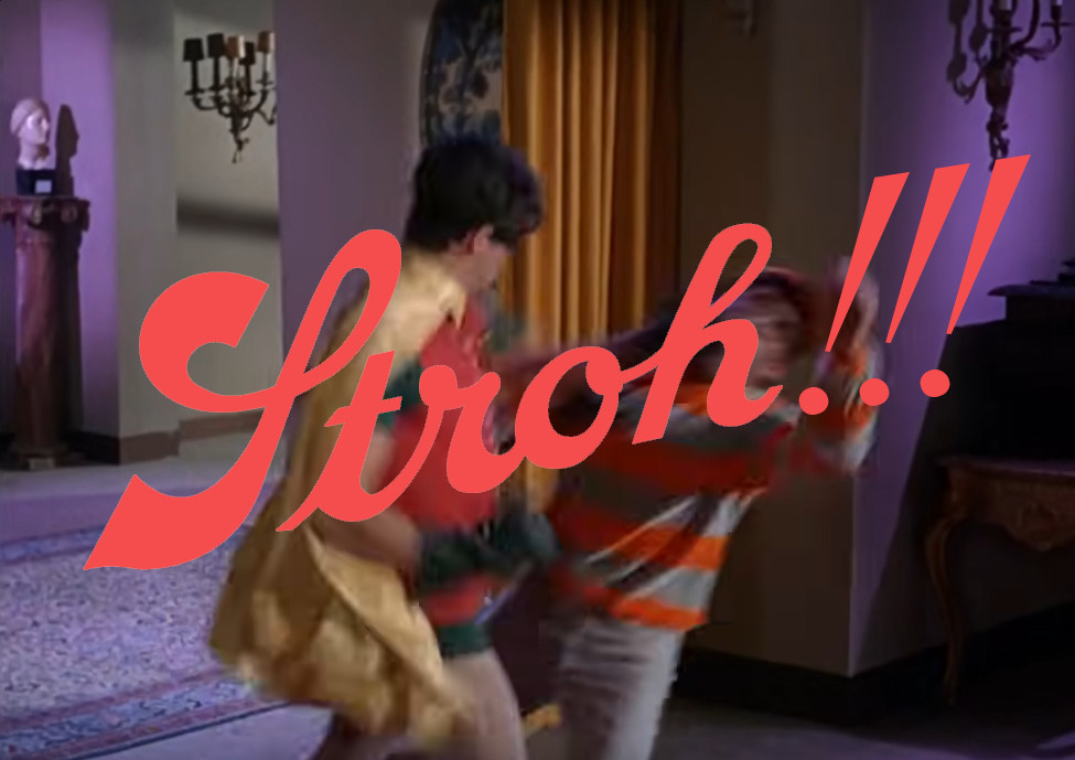 Robin punching some henchman in a red and grey striped shirt with the word "Stroh!!!" in orange/red at a jaunty angle