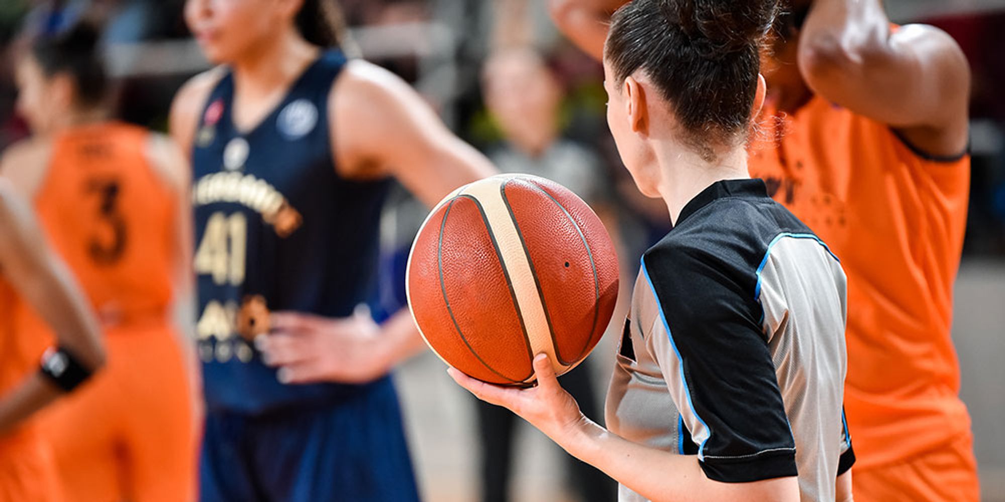 A basketball referee holding a ball.