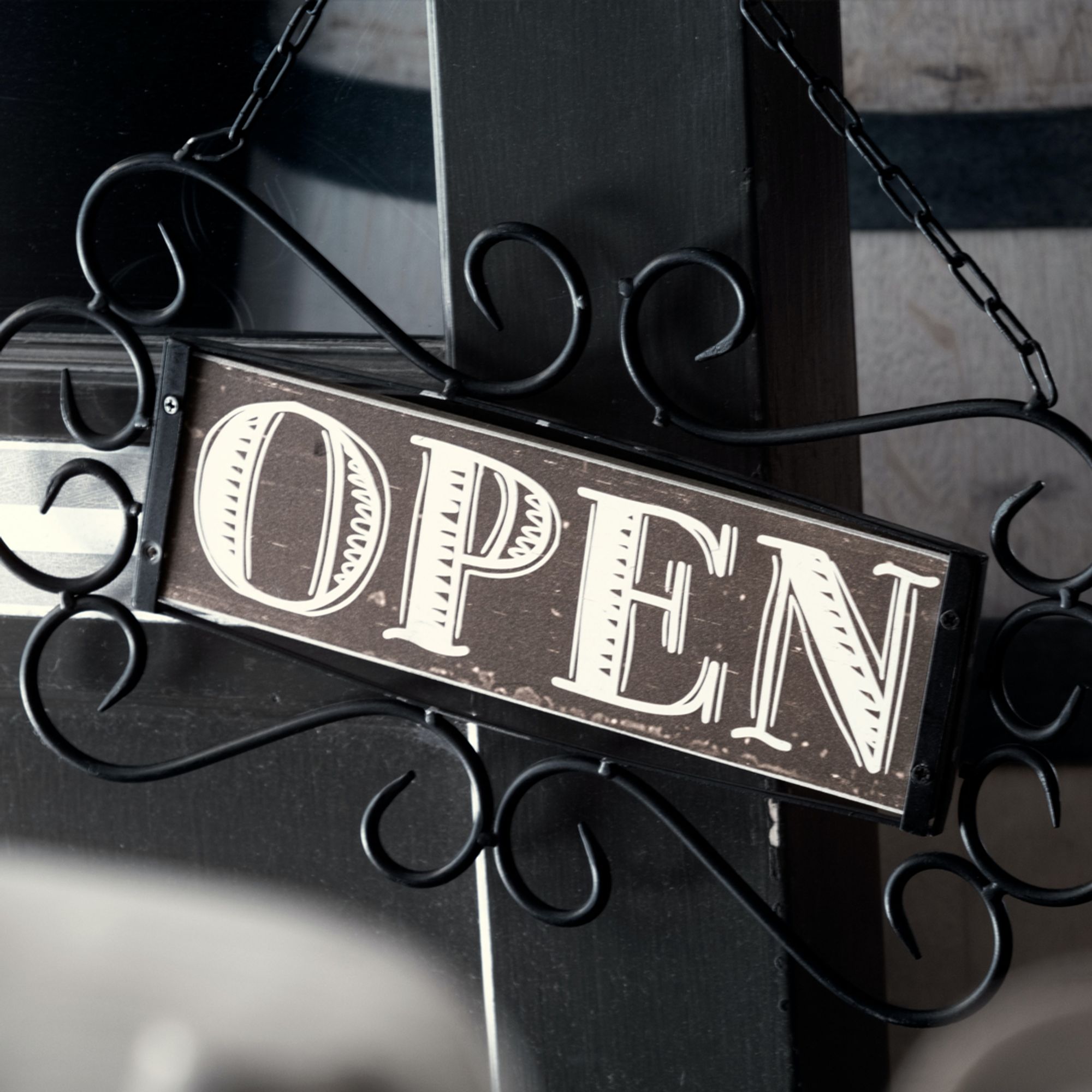 An open sign hanging on a door.