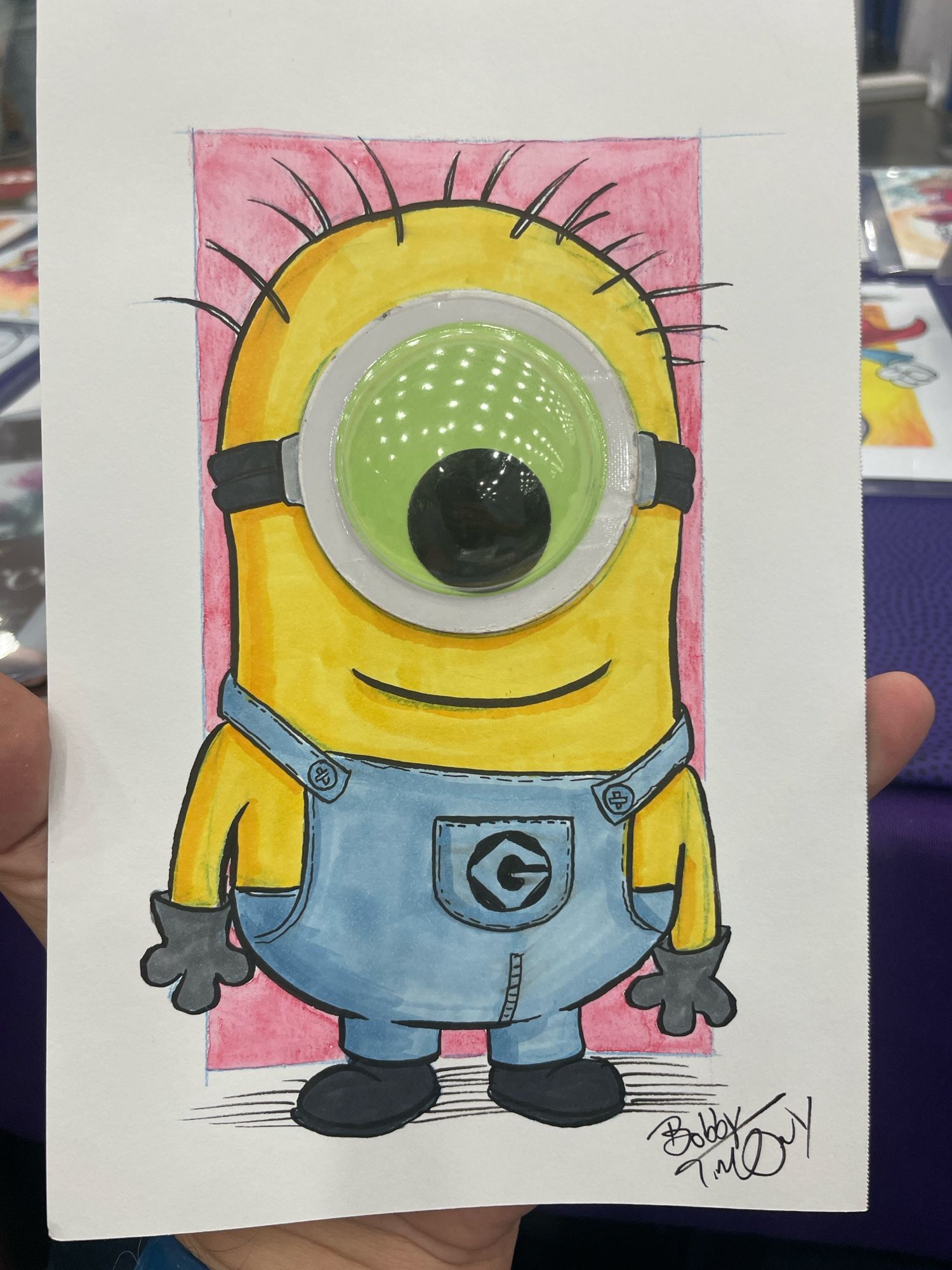 A drawing of a Minion that incorporates a big glow in the dark googly eye.