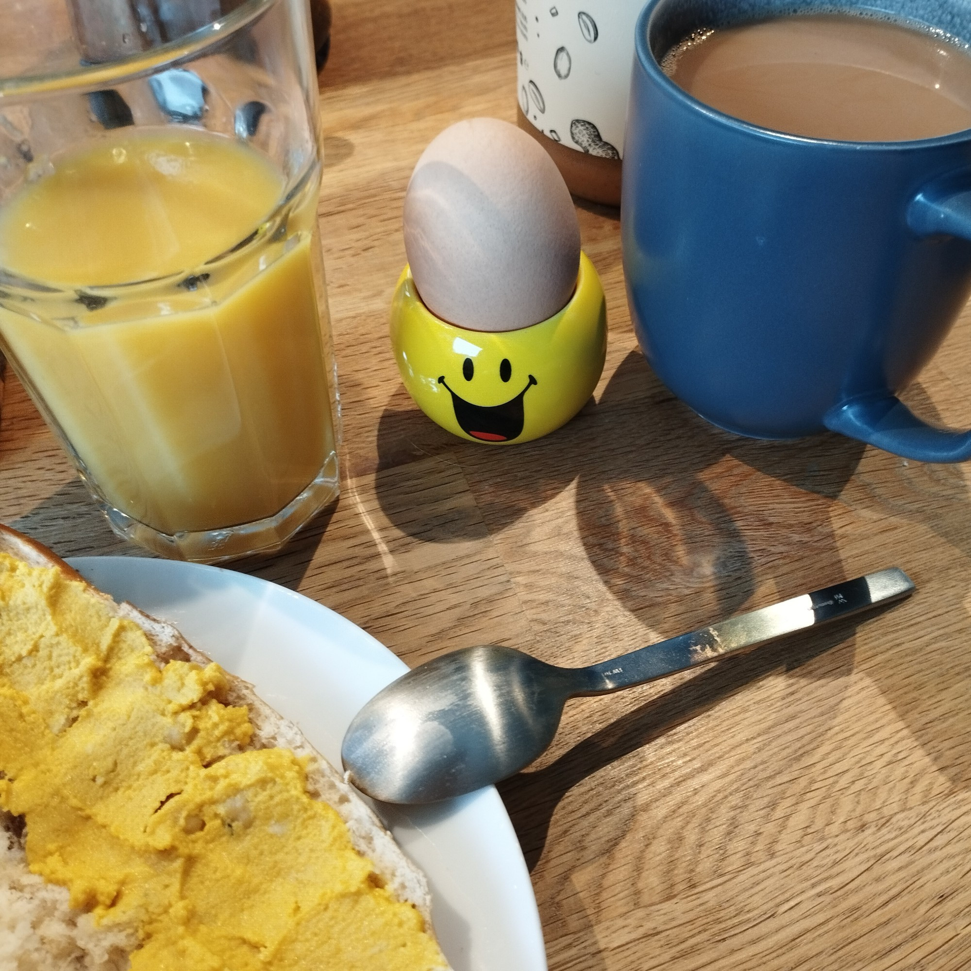 Kaffee, Ei, Orangensaft, Laugenstange mit Humus.