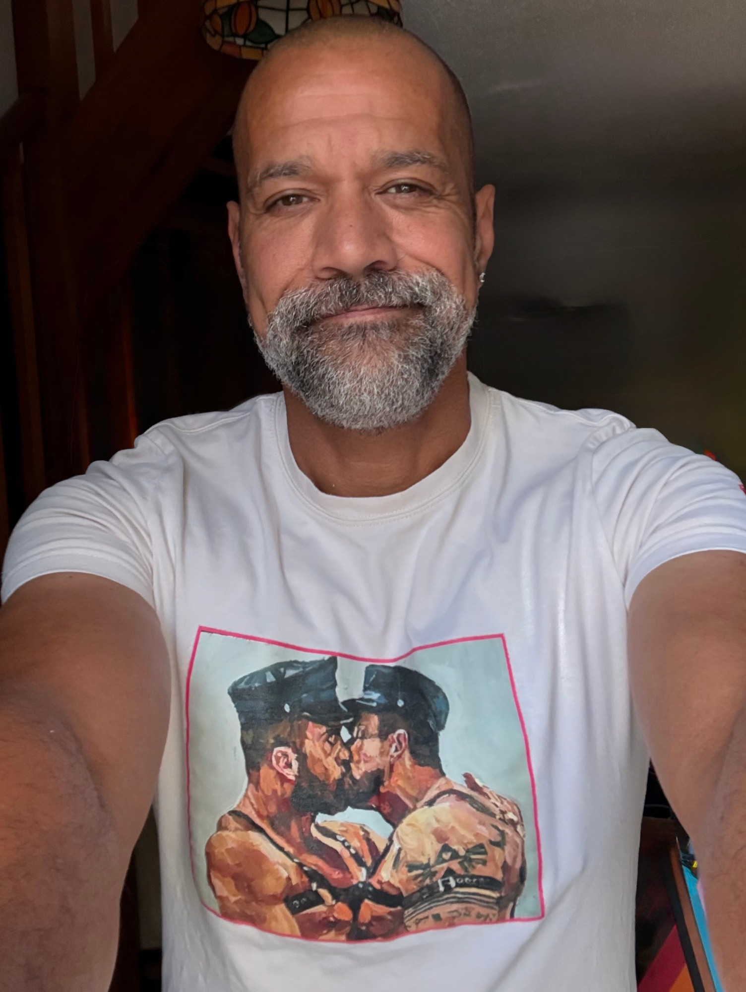 Coley stood in his lounge wearing a Den lounge wear T-shirt, Andy Sylvester artwork printed on the front.