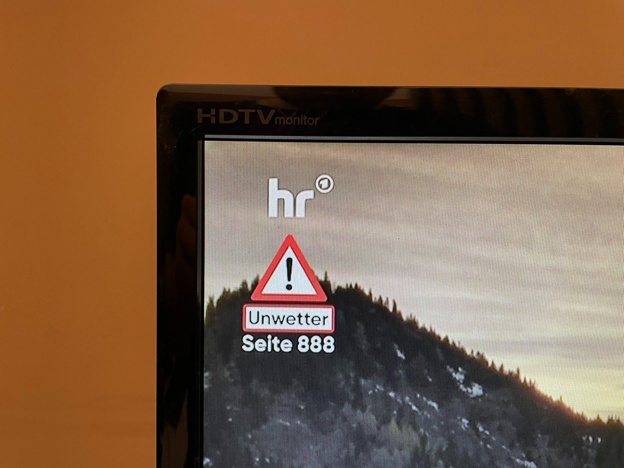 Live TV broadcast with a warning sign below the station logo: "Unwetter, Seite 888"