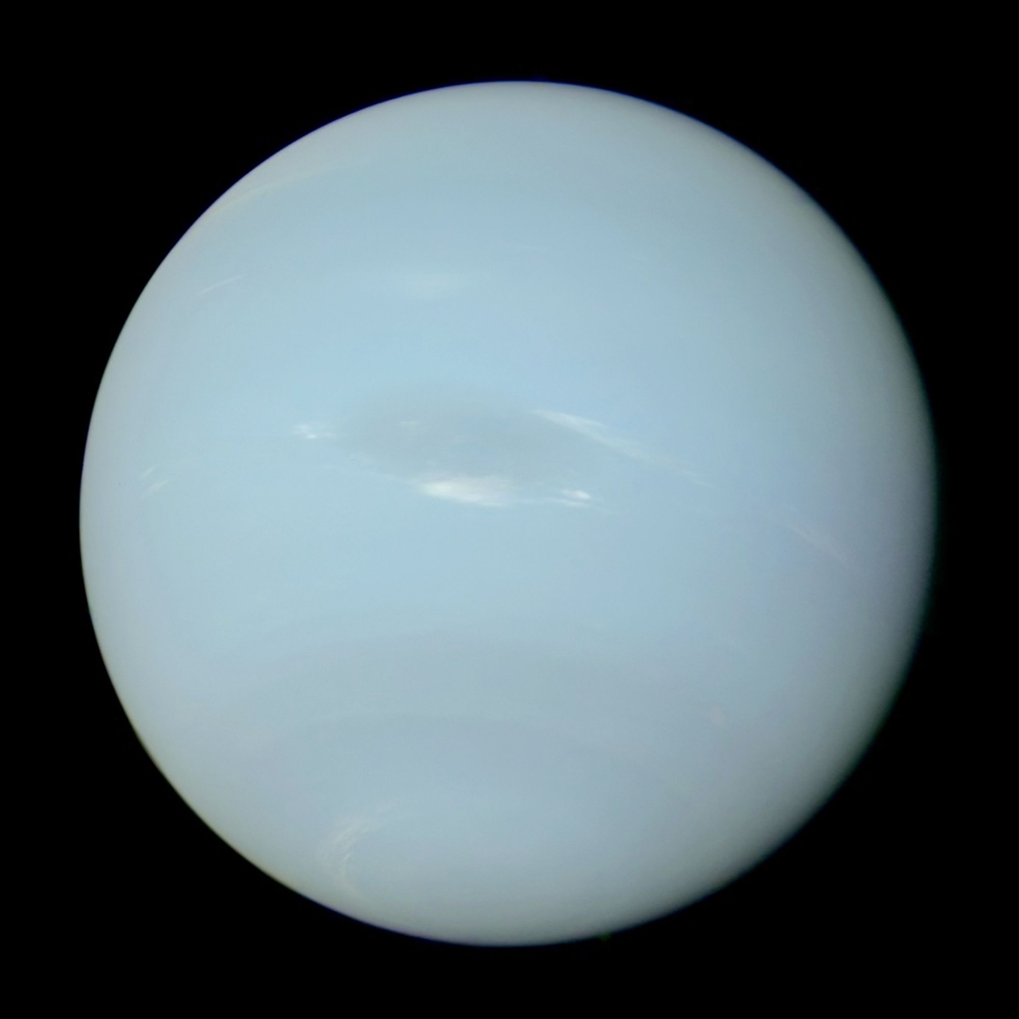 True color image of Neptune from Voyager II. The planet is pale blue (similar to Uranus) but it has some visible cloud features, including a huge oval storm (Great Dark Spot)