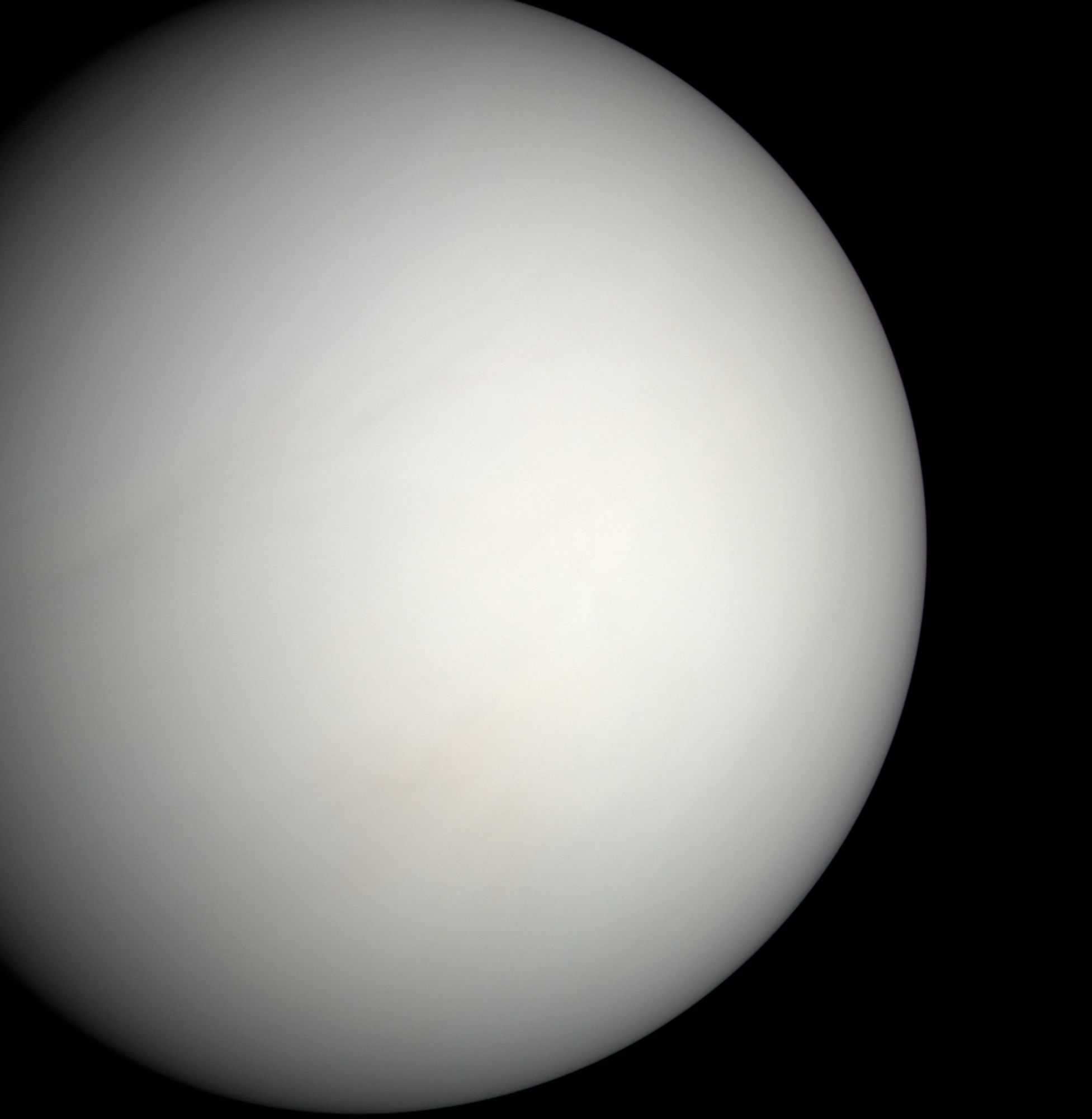 MESSENGER image of Venus. The planet is a virtually featureless pale tan ball. If you squint you can barely make out some texture in the clouds