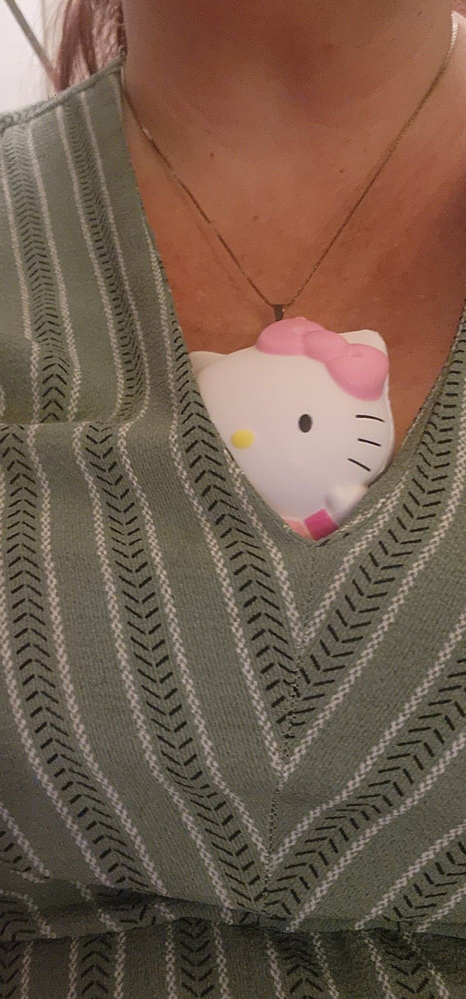 A Hello Kitty squishie peeks out of a woman's dress.