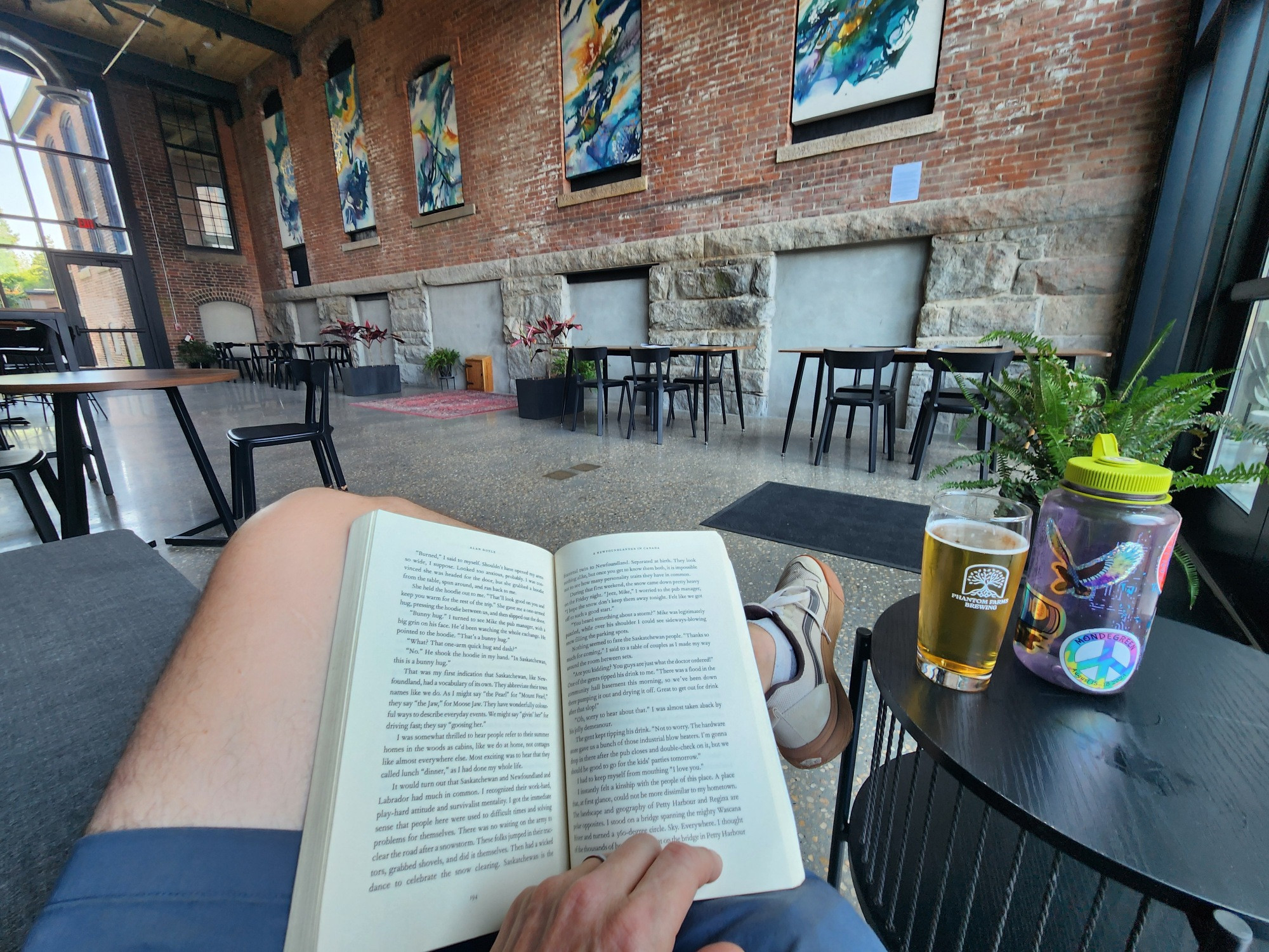A book on my lap on a couch in a big old brick mill building that is now Phantom Farms Brewing
