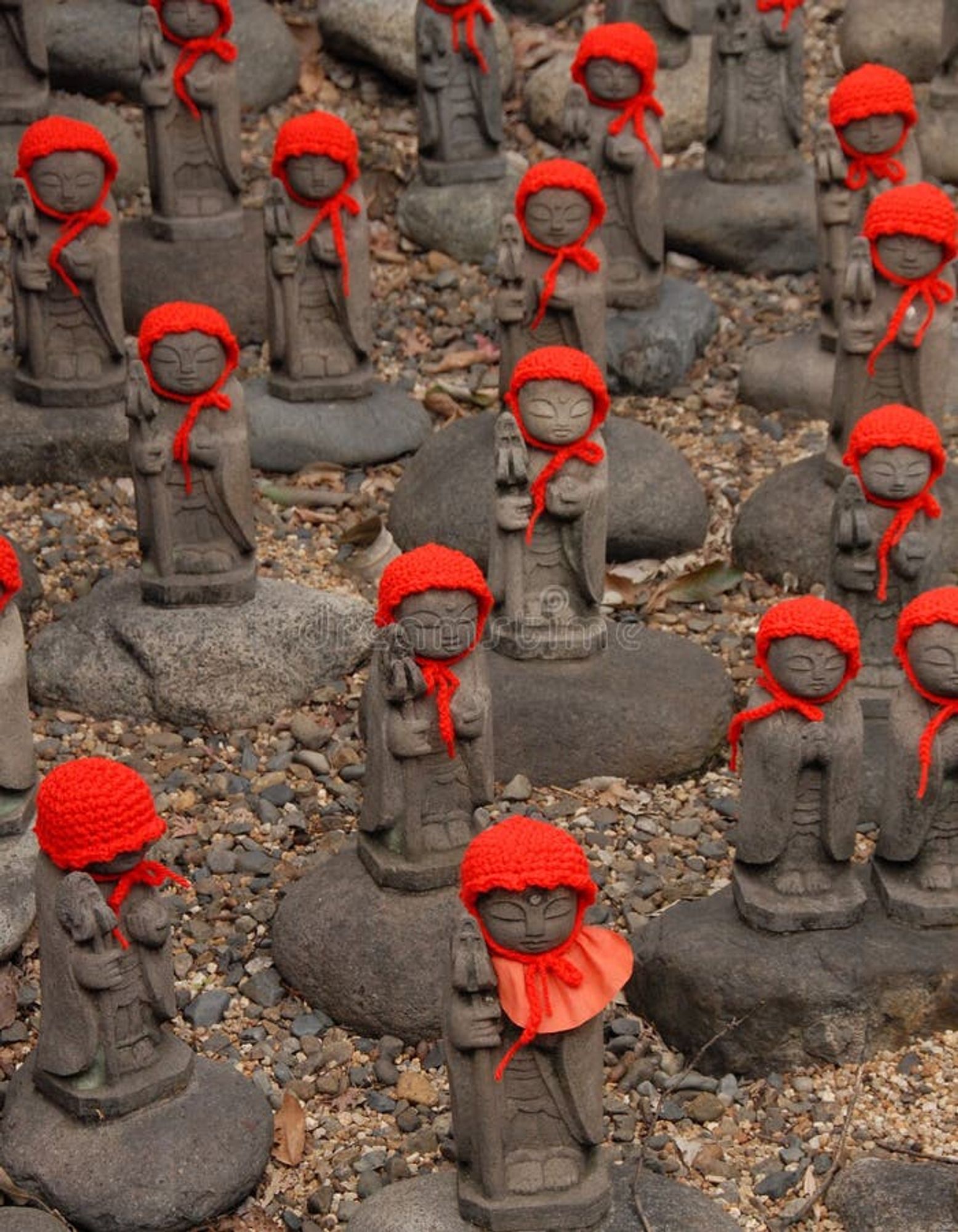 many jizos (arranged as if one were jizomaxxing) with knit red caps and bibs traditionally placed on jizo statues in winter to "keep them warm"