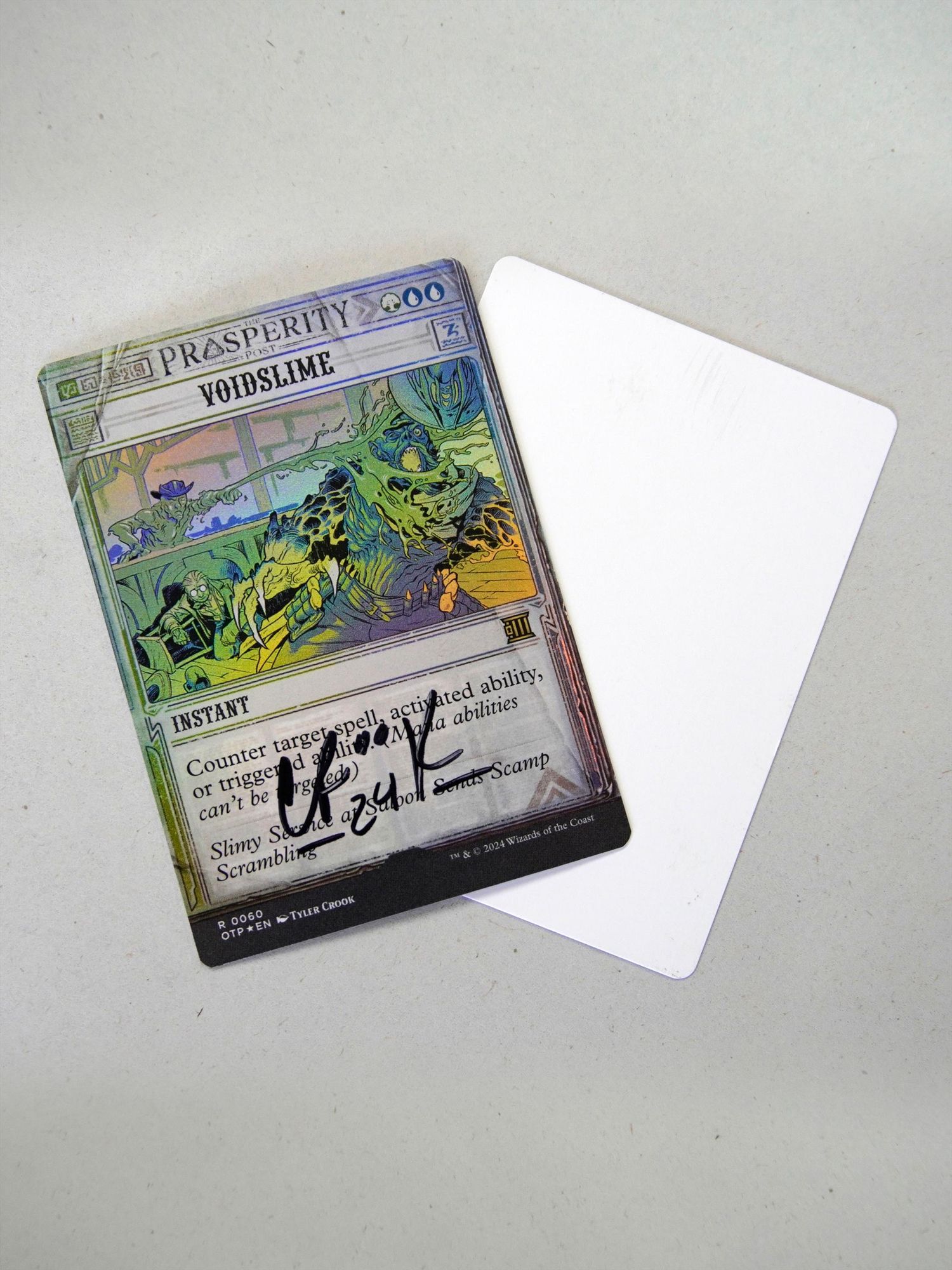 This is one of the signed foil Magic the Gathering cards, Voidslime. It has a second card underneath it, showing the blank side of the artist proof.