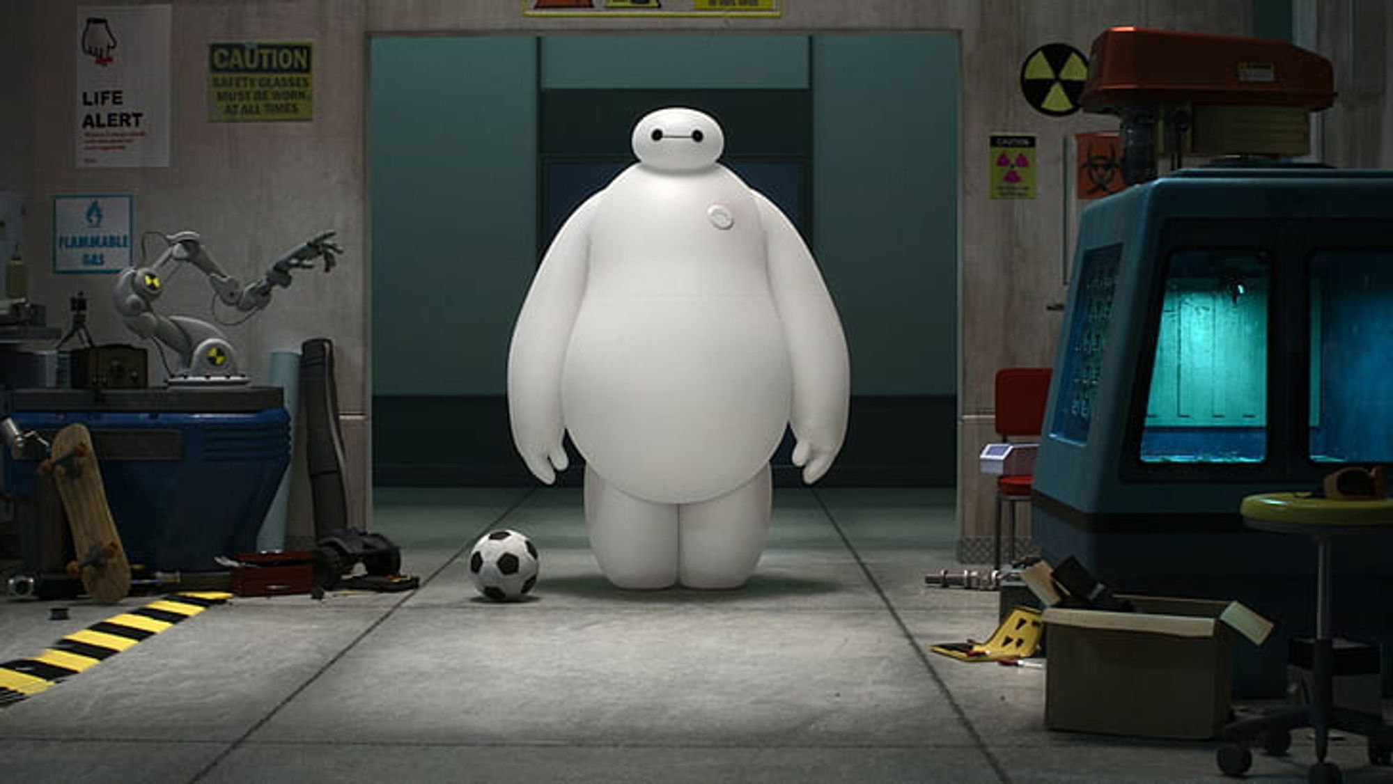 Baymax, with his big white marshmallowy body and his tiny little head, standing in a science lab next to a football.