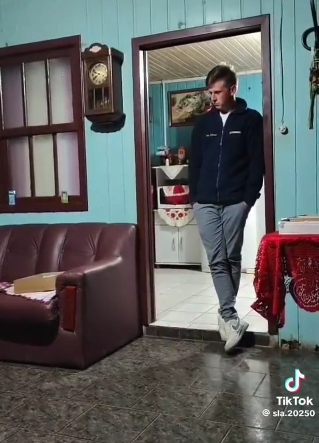 um homem branco usando agasalho parado encostado em uma porta com a expressão triste depois de sua traição ser exposta pra família pela esposa 
