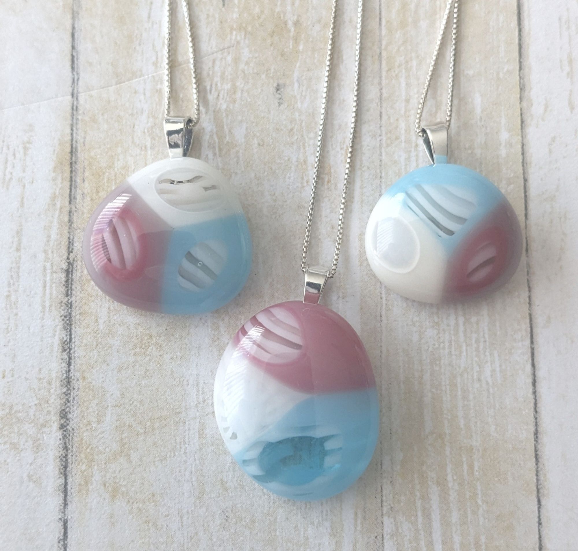 trans pride blob pendants with stripey middles