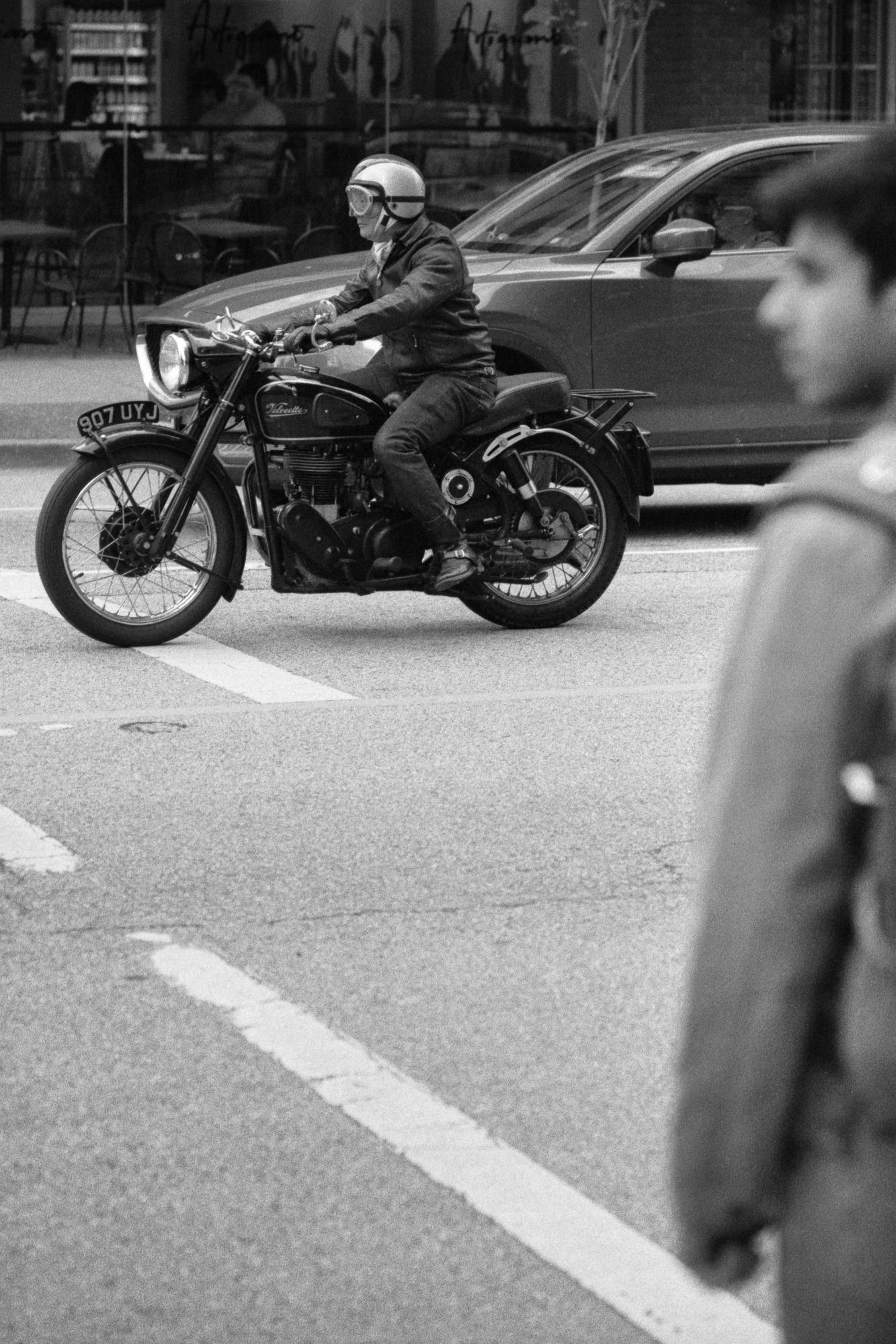 A pedestrian and motorcyclist look down Hastings St.