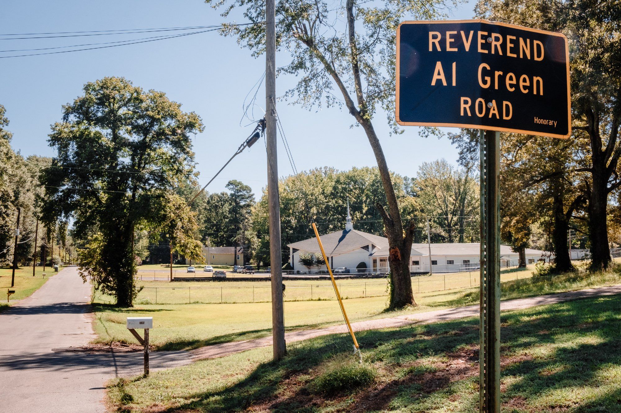 A view of the the sign for Reverend Al Green Road with Full Gospel Tabernacle in the distance.