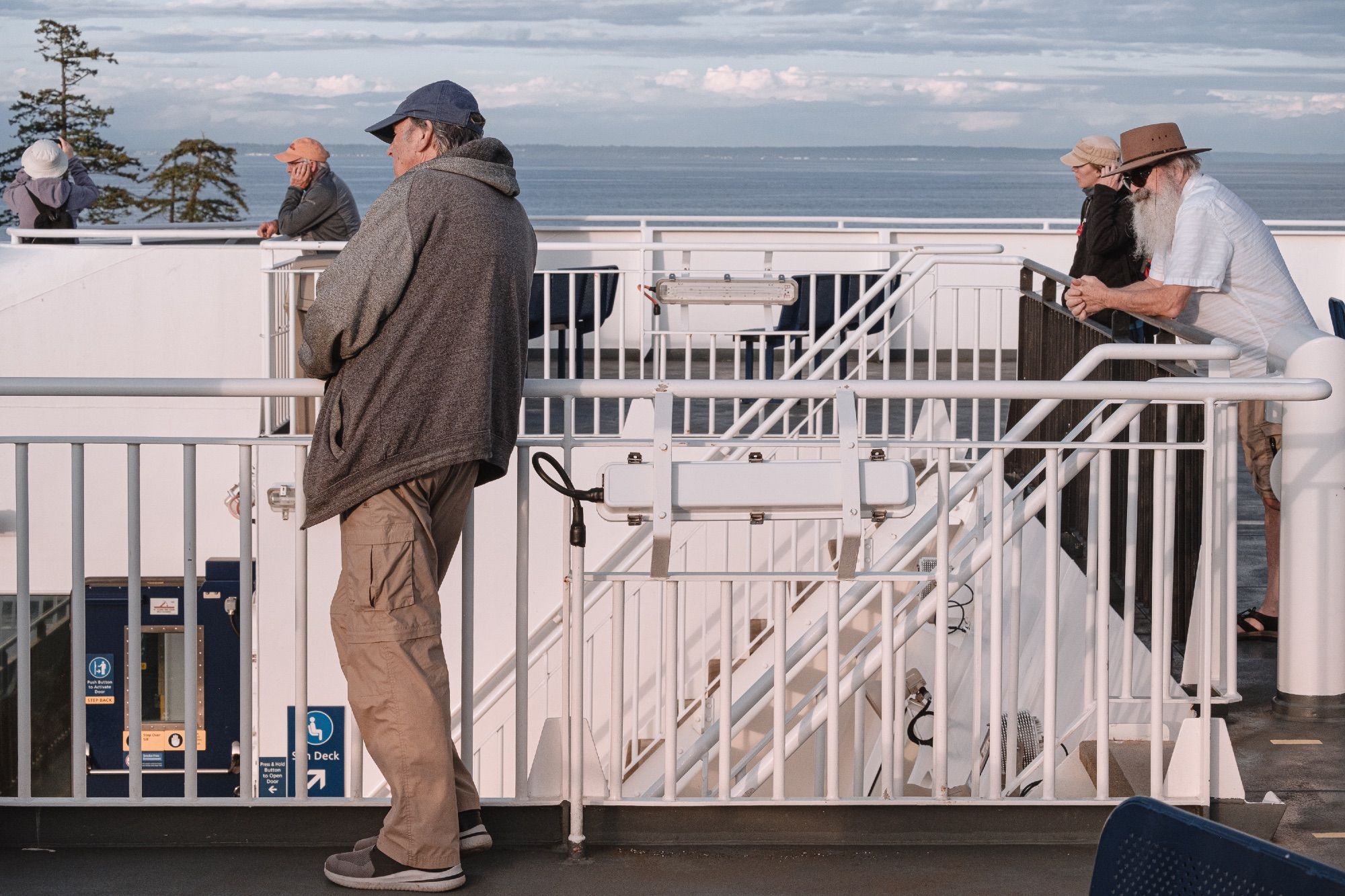 Passengers stand in the golden light watching cars and passengers board.